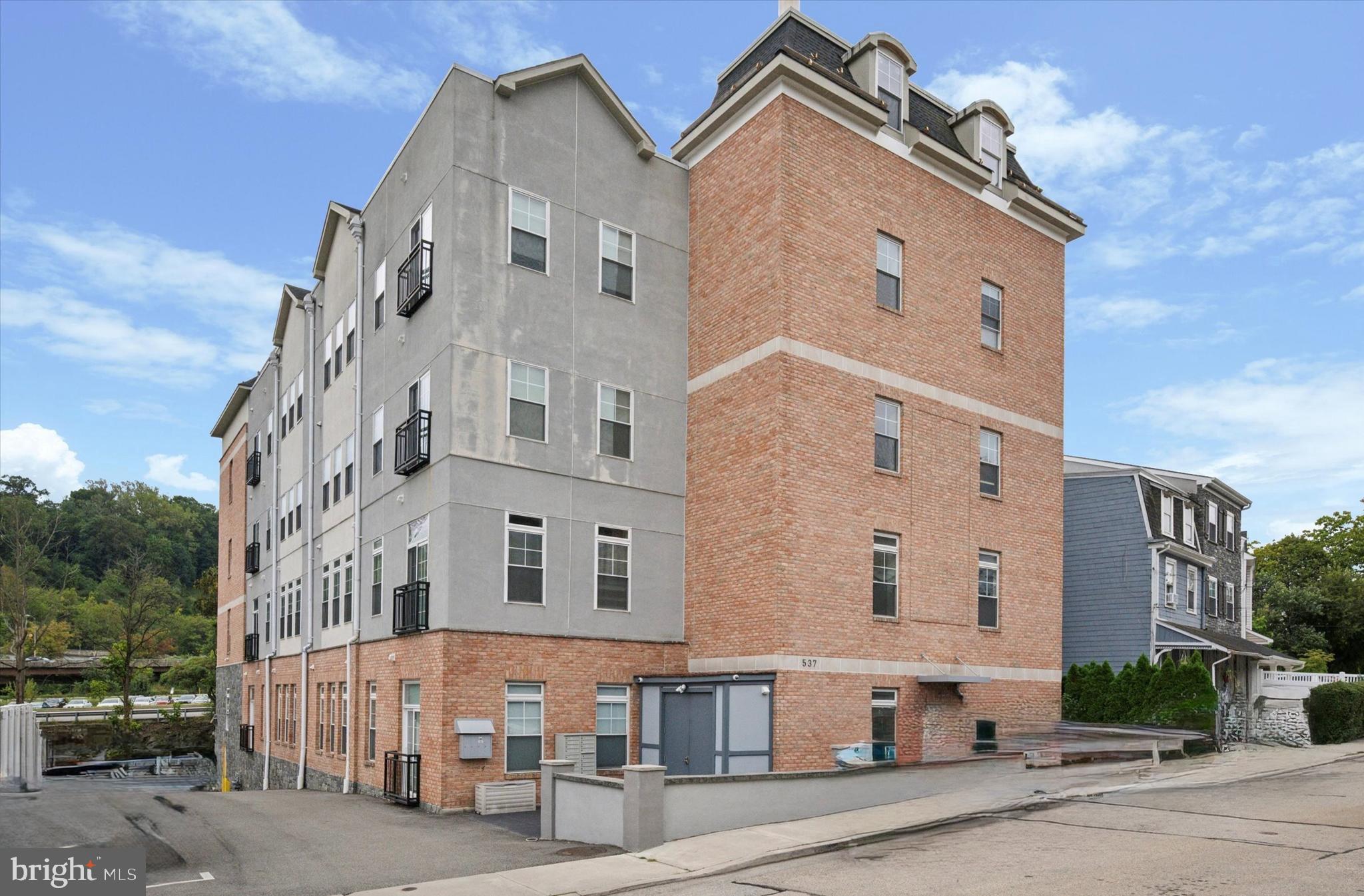 Welcome to AppleMoore Condominiums-beautiful newer-construction condos in the heart of West Conshohocken! This stunning, first-floor 2-bedroom, 2-full bathroom residence showcases 9'–10' ceiling heights, oversized windows that flood the home with natural light, and thoughtful details throughout.
Inside, you’ll find hardwood floors, high-end finishes, and custom millwork that elevate every space. The gourmet kitchen features granite countertops, stainless steel appliances, and ample cabinet storage with a floor to ceiling cabinet pantry. The open layout starts with the living area with plenty of room for a dining area or keep it a great room with a breakfast bar seating on the kitchen peninsula. Walk down the hall to the left to find the primary bedroom suite with sliding doors and Juliette balcony—perfect for enjoying fresh air. The walk-in closet is a dream with plenty of space for hanging clothes and dressers, shelves and shoes. The ensuite primary bathroom is beautifully appointed with a walk-in shower with glass surround.
On the other side of the condo, is the 2nd bedroom suite, complete with private entrance to the 2nd bathroom that also has another entrance to the main living area. A full-sized washer/dryer is stacked conveniently in the hall laundry closet, across from a large storage closet with easy access to all of your mechnicals. Need even more storage? You have elevator access to a basement storage cage where you can store your belongings all the way to the ceiling.
Two deeded assigned parking spaces (worth $15,000 each for a total of $30k in extra amenities) are included in the sale for your convenience. There are also several guest parking spots available as well as plenty of street parking for visitors.
Living at AppleMoore means enjoying a worry-free lifestyle—your condo fee includes common area maintenance, all exterior building maintenance, landscaping and video security features, snow removal, trash, and water. Easy access on the first floor means no elevator or stairs to climb when you need to walk the dog or go for an early morning run!
The location can’t be beat—enjoy walks to nearby parks like McKenzie Park and the Schuylkill River Trail for outdoor recreation. Walk to Conshohocken’s vibrant dining and nightlife just steps away, with favorites like Gypsy Restaurant, Salt & Stone, Nudy’s Café, Boathouse and American Pubs, and Hook & Ladder. Local events like ConshyFest add to the lively community atmosphere. With easy access to major highways such as 476 & 76, easy commuting to Philadelphia, the Main Line, or King of Prussia.
If you’re seeking modern luxury, low-maintenance living, 2+car parking and an unbeatable walkable location, this condo is a must-see!