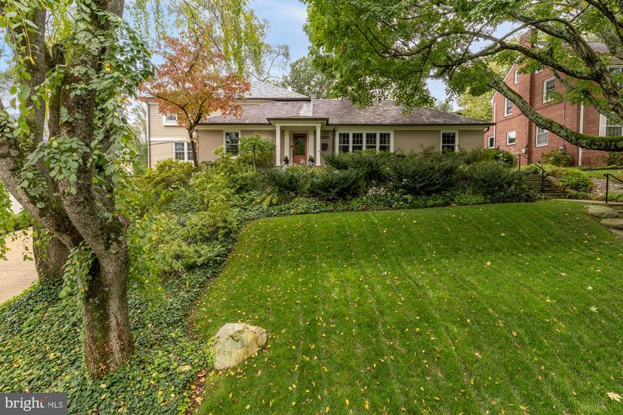 Sited in the tranquil Forest Hills neighborhood of Washington DC, this impressive residence offers an idyllic blend of comfort, style, and convenience. Surrounded by mature trees and a lush, expansive front yard, the house welcomes you with a beautifully landscaped walkway. Inside, the gracious entry foyer has hardwood floors and a double door coat closet, setting the tone for the elegantly appointed interiors. The living room is of generous scale with four oversized windows that bathe the space in natural light, complemented by a large central fireplace with a refined wood mantel and stone surround.
The light-filled formal dining room, with its sophisticated crown moldings, flows seamlessly into a well-appointed, updated kitchen. Featuring a large center island, high-end stainless-steel appliances, two sinks, and ample cabinetry, it offers both functionality and style for everyday cooking and entertaining. Other notable features include a spacious pantry, beverage fridge, breakfast bar seating, and dishwasher. The kitchen opens to an expansive two-story family room, where floor-to-ceiling windows offer serene green views of the meticulously landscaped rear yard, and a beautiful stone wall with a wood-burning fireplace adds warmth and character. The main level also hosts a desirable library/office with built-in desk, bookshelves, and cabinetry, alongside two sunny bedrooms and two full bathrooms.
The upper level is dedicated to a luxurious primary suite, complete with five oversized windows, an impressive walk-in dressing room with extensive built-ins, an additional large walk-in closet, and a spa-inspired bathroom with dual vanities, a skylight, freestanding soaking tub, and frameless glass shower. The lower level extends the living space with a sizable recreation room featuring a gas fireplace, wet bar, and wine storage, perfect for entertaining. A functional mudroom, gym, fourth bedroom, and two full bathrooms ensure comfort and convenience for residents and guests alike. The home also includes a two-car garage. Outside, the rear yard is exceptionally private, ideal for hosting gatherings with its large pool, hot tub, sundeck, multiple terrace spaces, built-in grilling station, and serene lily pond. The layered landscaping enhances the sense of privacy and tranquility, offering an extraordinary retreat within the city.
Forest Hills offers a perfect blend of suburban tranquility and city accessibility, making it a highly desirable neighborhood for those seeking a peaceful residential area within reach of urban amenities. Its tree-lined streets create a picturesque environment, while residents can take advantage of parks and cultural institutions including the Hillwood Estate, Museum & Gardens, and the National Zoo. The neighborhood also has close proximity to the Metro, facilitating effortless commutes to downtown DC, and top independent and public schools. This unique combination of accessibility, community, and scenic beauty makes Forest Hills an attractive place to live for those looking to enjoy all the wonderful experiences and opportunities that DC has to offer.