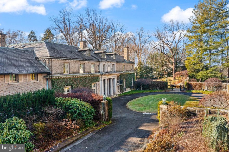 One of the last great estates of the Main Line, Camp Woods is a distinguished Italianate-style Villanova home on 3.4 beautifully landscaped private acres, offering a rare combination of historic architectural integrity and private recreational amenities, including a regulation-size hardball squash court. The ¼-mile drive, which is next to the Ardrossan Estate, leads into a walled courtyard with a circular drive.

One enters through a limestone porch with Doric columns into the transverse, covered, ceilinged hallway with French doors leading to the terrace, reflecting pool, and two loggias. Full of light, the main floor flows into the grand living room, the library, the morning room, and the dining room. All rooms have French doors and beamed or decoratively plastered ceilings. With fireplaces in each room and rich architectural detail, this is a house made for entertaining.

The kitchen is functional yet true to the home’s character, featuring custom wood cabinetry, hand-painted tile, a central island, and a high-quality range. The wood-paneled large butler’s pantry supports both everyday living and entertaining.

The bright studio/office offers a separate entrance and access to the terrace.

Upstairs, the home is anchored by a dramatic gallery-style hallway with soaring barrel-vaulted ceilings and abundant natural light. At each end of the upper level, two expansive primary bedroom suites create private retreats, each with its own fireplace, sitting or lounge area, bathrooms, dressing areas, and views over the gardens. There are two other large bedrooms with interior bathrooms in the main hall. Two additional bedrooms have bathrooms across the hall. There is also a second-floor laundry.

Additional features include nine fireplaces in total, one gas and eight woodburning, a wine cellar, regulation-size hardball squash court, playroom, workshop, and mushroom cellar.

The property has stunning mature trees, raised garden beds, garden paths, and stone walls.

The residence is in an excellent state of preservation. With the exception of certain service and utility areas, the home retains its original architectural integrity. Camp Woods is an exceptional home on a well-landscaped private property in the highly sought-after Radnor School District.