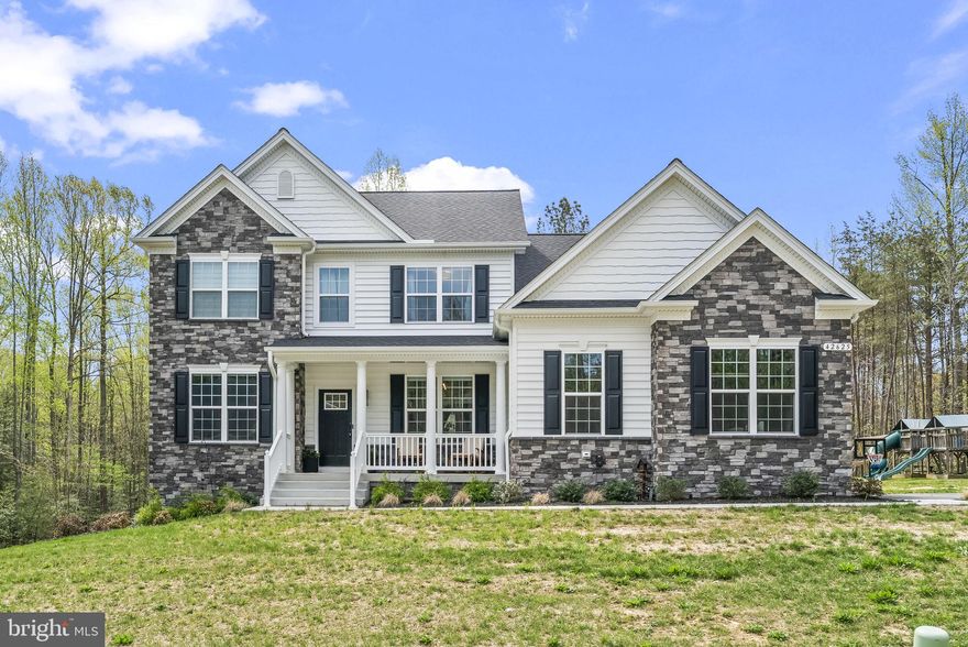 Welcome to refined living in this exceptional QBHI Fairfax model, perfectly situated on nearly two private acres and just 16 months young. Located in the highly sought-after Broyhill community of Leonardtown, this beautifully crafted home blends luxury, comfort, and thoughtful design at every turn.From the moment you arrive, you’ll appreciate the expansive, mostly flat yard—ideal for outdoor enjoyment—with a pool, swing set, and storage shed already in place. The attached two-car garage is equipped with a Tesla charger, adding modern convenience to this stunning property.Step inside to discover a truly gourmet kitchen that will impress even the most discerning chef. Featuring striking white quartz countertops with elegant gray veining, custom tan wood cabinetry with burnished copper finishes, high-end multi-paneled Samsung appliances, and a charming farmhouse sink, this space is both functional and beautiful. The adjoining breakfast nook sits within a generous 4-foot bump-out morning room, filling the space with natural light.The family room is a showstopper with its cozy gas fireplace and dramatic floor-to-ceiling stone façade—perfect for gathering or relaxing evenings at home. The main level also offers a formal dining room, an expansive side-by-side office, a convenient drop zone with built-in storage leading to the garage, a private bedroom with a full attached bath, and an additional powder room for guests.Downstairs, the fully finished basement expands your living space with a large recreation area perfect for movie nights or entertaining, along with an additional bedroom and full bath.Upstairs, you’ll find four generously sized bedrooms, including a luxurious primary suite complete with a sitting area, dual walk-in closets, and a spa-inspired bath featuring dual sinks with ample cabinetry, a soaking tub, and a spacious 6' x 6' deluxe shower. Three additional bedrooms share a well-appointed hall bath with dual sinks, and the conveniently located upper-level laundry room makes everyday living effortless.Nestled in a community known for its curated selection of craftsman-style homes and spacious lots, Broyhill offers both privacy and charm. Enjoy peaceful surroundings while being just minutes from downtown Leonardtown’s shopping and dining, as well as nearby Dorsey Park for outdoor recreation.This is the one you’ve been waiting for—schedule your private tour today!