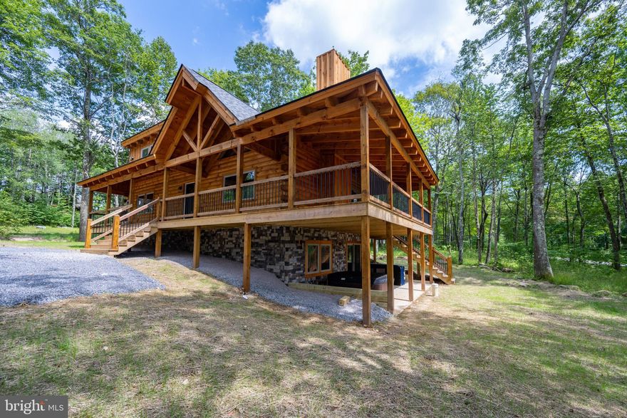 Tucked inside a gated ridgetop community beside Lodestone Golf, this new-build chalet keeps it clean and classic. Eight-inch logs frame the vaulted living room, anchored by a two-story stone fireplace and wide plank floors. The kitchen cuts sharp with granite, hardwood cabinetry, and stainless appliances. 5 bedrooms, 4.5 baths, and nearly 3,000 square feet stretch across three levels, including a finished walk-out basement with additional rec space. Massive covered wrap around deck and lower-level hot tub patio provide ample outdoor living space. Private lot, fully furnished, and just minutes to Local Restaurants, Wisp Resort, and Deep Creek Lake. Call today for details!