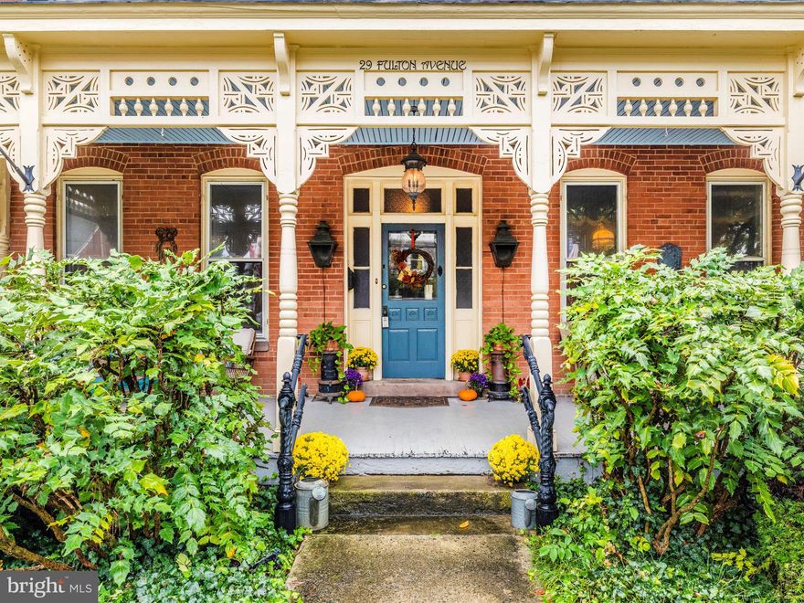 Discover timeless character and a rare offering in Walkersville at 29 Fulton Avenue. Built in 1900, this stately three-story brick Victorian has been lovingly restored over time, blending preserved architectural details with thoughtful modern updates for today’s lifestyle. The exterior walls, 3 bricks thick and crafted by Walkersville Brick & Tile Works stand as a testament to the lasting craftsmanship. Inside, more than 3,000 sq feet of finished living space is enhanced by soaring 10’+ ceilings, tall proportioned moldings, decorative crown details, heart pine hardwood floors, transom windows, and intricate ceiling medallions. Built-in display cabinetry, pocket doors, and even a decorative newel post cap that conceals a secret compartment remain beautifully intact. The grandeur of this home reveals itself the moment you enter, where original character immediately transports you to an era bygone. The dining room, perfect for large gatherings, features bay windows with plantation shutters, a wood-burning fireplace with an elaborate mantel, a tray ceiling with a ceiling medallion, and a statement chandelier. A true centerpiece of the home, the modernized kitchen boasts ten-foot pocket doors, a masonry wood-burning heater crafted from original bricks, soapstone counters, stainless steel appliances, and abundant maple cabinetry. The recent remodel provides beauty and functionality, offering plenty of space for cooking and entertaining.  Access to the second staircase is shared between the kitchen and the family room. A bonus room off the kitchen has a 2nd wall oven and has been used as a butler's pantry room by the current owners. The family room centerpiece is the Barlett Hayward Latrobe stove, manufactured in Baltimore, Md, and modified for propane which adds warmth and a historical feel to the room. Other features are the surround sound access grates, secret storage areas, (2) ceiling medallions with ornate chandeliers, the second full bath with stained glass doors, and a claw-foot bathtub. The third staircase can be found in this room and is adorned with a custom iron handrail. A mud room with heated floors and floor-to-ceiling cabinetry serves as a second entry point to the home and flows into the family room. Cozy up with a book and watch the snow fall from the four-season room with floor-to-ceiling Eze-Breeze windows and a propane stove. Four bedrooms, a modern full bath, and laundry are all generously sized and full of natural light. The primary bedroom has a bay window with plantation shutters and direct access to the full bath. A rear bedroom has access to the third staircase, believed to be used by the house staff in the late 19th century. A walk-up attic with over 1,700 square feet of floored, fully insulated space provides endless possibilities for additional finished rooms. Outdoor living is equally inviting. A cozy side porch and a large covered front porch with intricate gingerbread trim provide the perfect backdrop for quiet mornings and unhurried evenings. A custom wrought iron border fence and handrail complements the home’s Victorian style, and is lined with fragrant red roses, creating a striking first impression. Gas lit front porch lamps frame the front entry and greet you with a warm, flickering light, while details like the original mail slot and intricate mechanical doorbell preserve the home’s historic charm. The roof is a combination of slate and asphalt and is equipped with half-round gutters and period lightning rods, while the large driveway leads to a darling carriage house adding function and character.  Located in the heart of Walkersville, this home offers a lifestyle that blends community, convenience and charm. Walk to schools, the library, church, and restaurants. Opportunities like this are rare-a home rich with character, space, and history, ready for its next chapter. This isn’t just a place to live, but a place to grow, create lasting memories, and carry forward with pride.