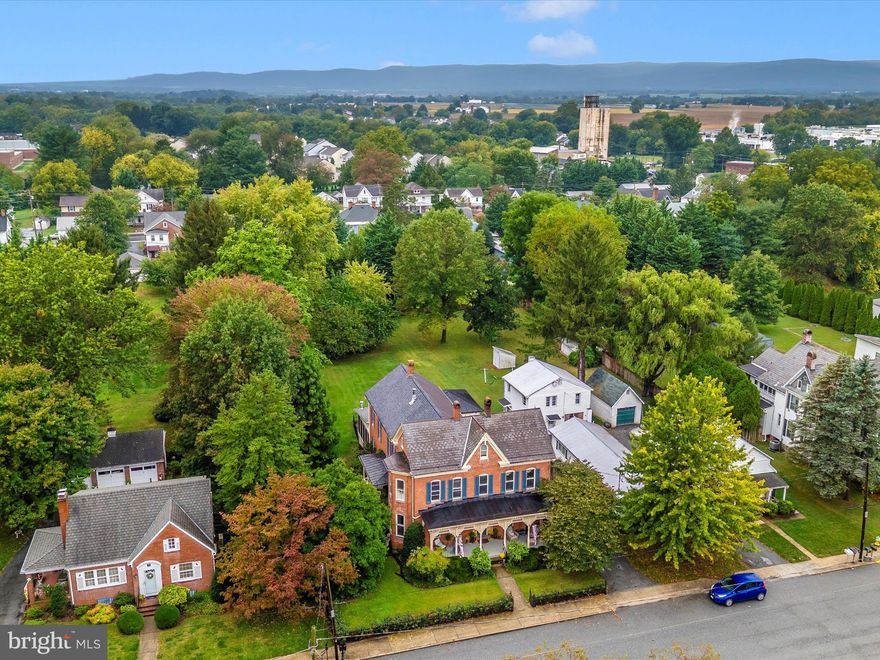 Discover timeless character and a rare offering in Walkersville at 29 Fulton Avenue. Built in 1900, this stately three-story brick Victorian has been lovingly restored over time, blending preserved architectural details with thoughtful modern updates for today’s lifestyle. The exterior walls, 3 bricks thick and crafted by Walkersville Brick & Tile Works stand as a testament to the lasting craftsmanship. Inside, more than 3,000 sq feet of finished living space is enhanced by soaring 10’+ ceilings, tall proportioned moldings, decorative crown details, heart pine hardwood floors, transom windows, and intricate ceiling medallions. Built-in display cabinetry, pocket doors, and even a decorative newel post cap that conceals a secret compartment remain beautifully intact. The grandeur of this home reveals itself the moment you enter, where original character immediately transports you to an era bygone. The dining room, perfect for large gatherings, features bay windows with plantation shutters, a wood-burning fireplace with an elaborate mantel, a tray ceiling with a ceiling medallion, and a statement chandelier. A true centerpiece of the home, the modernized kitchen boasts ten-foot pocket doors, a masonry wood-burning heater crafted from original bricks, soapstone counters, stainless steel appliances, and abundant maple cabinetry. The recent remodel provides beauty and functionality, offering plenty of space for cooking and entertaining.  Access to the second staircase is shared between the kitchen and the family room. A bonus room off the kitchen has a 2nd wall oven and has been used as a butler's pantry room by the current owners. The family room centerpiece is the Barlett Hayward Latrobe stove, manufactured in Baltimore, Md, and modified for propane which adds warmth and a historical feel to the room. Other features are the surround sound access grates, secret storage areas, (2) ceiling medallions with ornate chandeliers, the second full bath with stained glass doors, and a claw-foot bathtub. The third staircase can be found in this room and is adorned with a custom iron handrail. A mud room with heated floors and floor-to-ceiling cabinetry serves as a second entry point to the home and flows into the family room. Cozy up with a book and watch the snow fall from the four-season room with floor-to-ceiling Eze-Breeze windows and a propane stove. Four bedrooms, a modern full bath, and laundry are all generously sized and full of natural light. The primary bedroom has a bay window with plantation shutters and direct access to the full bath. A rear bedroom has access to the third staircase, believed to be used by the house staff in the late 19th century. A walk-up attic with over 1,700 square feet of floored, fully insulated space provides endless possibilities for additional finished rooms. Outdoor living is equally inviting. A cozy side porch and a large covered front porch with intricate gingerbread trim provide the perfect backdrop for quiet mornings and unhurried evenings. A custom wrought iron border fence and handrail complements the home’s Victorian style, and is lined with fragrant red roses, creating a striking first impression. Gas lit front porch lamps frame the front entry and greet you with a warm, flickering light, while details like the original mail slot and intricate mechanical doorbell preserve the home’s historic charm. The roof is a combination of slate and asphalt and is equipped with half-round gutters and period lightning rods, while the large driveway leads to a darling carriage house adding function and character.  Located in the heart of Walkersville, this home offers a lifestyle that blends community, convenience and charm. Walk to schools, the library, church, and restaurants. Opportunities like this are rare, and it's ready for its next chapter! This isn’t just a place to live, but a place to grow, create lasting memories, and carry forward with pride. Watch the YouTube tour!