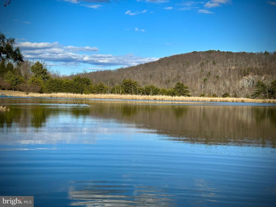 REDUCED!  This 3-acre parcel of raw land offers an awe-inspiring canvas of untouched beauty. The landscape is dominated by the rugged majesty of the tall hardwoods, with plenty of flat ground to start painting on this blank canvas.  If you’re looking for a full time residence, or a weekend retreat, this lot will not disappoint.  The subdivision is unspoiled as evidenced by the sparsity of homes..  On this lot, you will not see your neighbors and you’re within a short distance of the private community lake where you can canoe, or kayak, or even have a non-powered boat.  That lake could easily personify the “lazy days of summer”, but would be equally as enjoyable in the spring and fall.  In a word: peaceful. 

Electric is available and there is a septic permit on file for the property as well.  A well will need to be drilled. With this parcel, you're not just buying land; you're investing in a lifestyle that celebrates the  beauty of mountains, the tranquility of wooded landscapes, and the luxury of a private lake. This is a place where the stresses of the world melt away, replaced by the peace and wonder of the great outdoors.  This location is in proximity to Cacapon State Park.  Easy commute to Winchester, Virginia as well. Come experience this lot today.  You will be glad that you did.