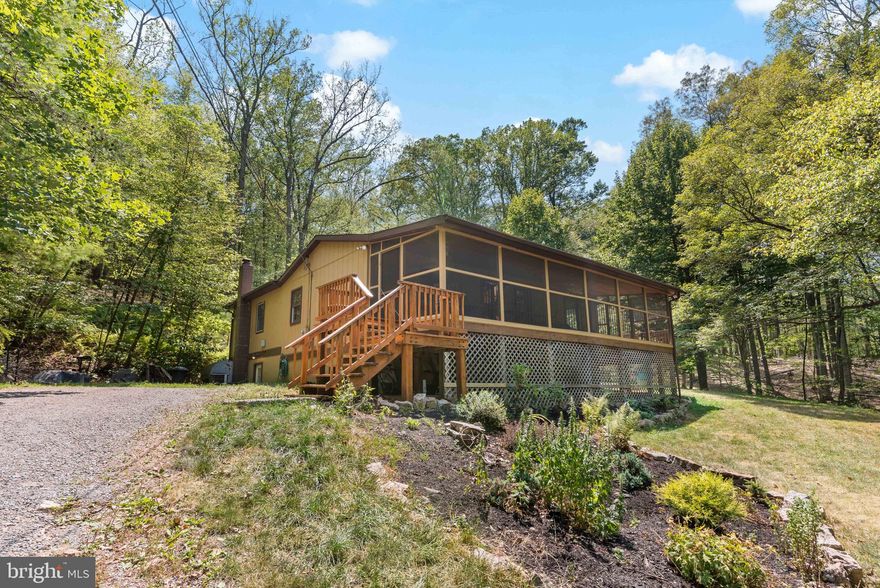 Welcome to 132 Hill Top Rd in Great Cacapon, WV! This inviting 3-bedroom, 2-bathroom home sits on 2 lots totaling 6.01 acres, perfect for those who value privacy and nature. Stay cozy inside with two wood-burning stoves and enjoy the large screened-in porch, ideal for relaxing and entertaining. With fiber optic internet, you can easily work from home or stream your favorite shows. Cacapon RIver Rapids community has private access to one of the most scenic areas of the Cacapon River, offering great opportunities for fishing and kayaking. Just 15 minutes from the charming town of Berkeley Springs, you'll have convenient access to shops, dining, and local attractions. This home is perfect for anyone looking for a peaceful retreat. Don't miss out on this fantastic opportunity!