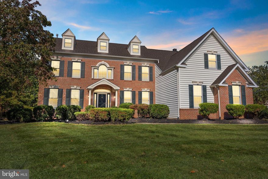 Welcome to 1120 Kingsley Hall Drive, a stately brick-front Colonial set at the end of a quiet cul-de-sac in the desirable Kingsley at Gwynedd community. This home, the highly sought-after Cambridge Traditional Model, boasts over 4,400 square feet of living space, 4 bedrooms, and 4.5 bathrooms. While retaining its classic finishes, the property is in impeccable, move-in condition, offering incredible size and a perfect foundation for the next owner's personalization. Step through the impressive front entry, framed by Palladian windows, into a bright, two-story Foyer featuring gleaming hardwood floors and a graceful turned staircase. The main level is generously sized, with notable 10-foot ceilings throughout, featuring an elegant Formal Dining Room, which is conveniently served by a Butler’s Pantry, and a spacious first-floor Study/Office. The heart of the home is the Gourmet Center Island Kitchen, which flows seamlessly into an enlarged Breakfast Area. The sun-drenched, two-story Family Room showcases a wall of windows, a volume ceiling, and a cozy gas fireplace, complemented by a sun-filled Morning Room or Conservatory for additional flexible living space. Ascend to the upper level via one of two staircases where the expansive Owner’s Suite awaits, a large retreat boasting a peaceful sitting area and a spacious Dressing Hall flanked by four total closets, including two spacious walk-ins, and a Master Bath featuring a volume ceiling. Additional exceptional features include a full finished basement with 9-foot ceilings, and a coveted 3-car side-entry attached garage, all set within the highly-regarded North Penn School District and offering easy access to major commuter routes, shopping, and dining. Schedule your private tour today and experience the size and quality of this sought-after home in Kingsley at Gwynedd.