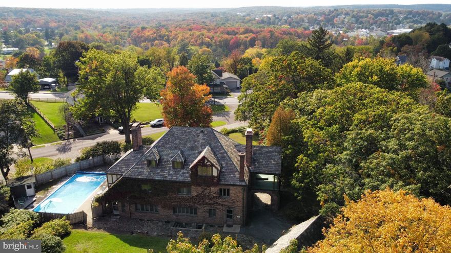 This majestic all stone English Tudor Style home sits in the desired neighborhood of Curtis Park and is a quick commute to State College. This home boasts with charm the minute you walk in the front door where you are met with a large foyer, cathedral ceilings and a beautiful spiral staircase. The first floor offers a kitchen with a breakfast nook and butler's pantry, a formal dining room, a spacious family room where you will find a beautiful fireplace, and if that isn't enough, it has a bonus room, powder room and large sunroom with another fireplace that overlooks the gorgeous built-in pool.  The second floor offers a mother-in law suite with kitchenette, 2 full baths, 3 Bedrooms, sitting area, and sun porch.  Additional living space is located on the third floor of this charming home where you will find the maids quarters with a bedroom, full bath, a lovely walk in Cedar Closet and 2 additional rooms for storage. The basement has a laundry room, coal room, fruit cellar, and game room with another fireplace. This home has tons of potential and is a must see to appreciate home.
