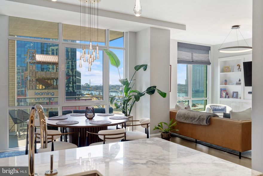 Welcome to waterfront, elevated city living at The Liberty Harbor East, one of the most sought-after boutique residences in Harbor East, where modern design meets vibrant waterfront energy.
This extraordinary fifth-floor residence, built in 2019, offers 1,163 square feet of refined living space with one bedroom, one full bath, and a versatile den. 

Recently enhanced with thoughtful, high-end upgrades, the home now features fresh designer paint, new modern lighting with Lutron smart lighting system, and custom built-ins that elevate both style and functionality. The layout has been reimagined with the removal of the wall between the den and living area, creating an even more open and expansive living space, perfect for today’s lifestyle. 

From the moment you enter, you’re greeted by soaring 10-foot ceilings and dramatic floor-to-ceiling windows that flood the home with natural light while showcasing breathtaking southwest views of downtown Baltimore. New custom blinds, fully integrated with Alexa for smart home convenience, add both luxury and ease of living.

The living and dining areas flow seamlessly into a chef’s kitchen featuring sleek Italkraft cabinetry, premium Thermador appliances, and a striking Calacatta marble waterfall island, ideal for entertaining. Tucked privately beyond the foyer, the spacious primary suite has been elevated with a stunning custom wood-paneled accent wall and offers access to a private balcony overlooking the iconic Inner Harbor. 

The spa-inspired bath is a true retreat, featuring Carrara marble, Kallista and Kohler fixtures, an expansive walk-in shower, and a custom dual vanity, while the oversized walk-in closet provides abundant storage.  Additional upgrades include a whole-house water filtration system and a new hot water heater, ensuring comfort and peace of mind. 

Residents of The Liberty enjoy a full suite of resort-style amenities, including a rooftop infinity pool with cabanas, a state-of-the-art fitness center and yoga studio, pet park with agility equipment, and beautifully designed social spaces such as a clubroom with indoor/outdoor bar, private dining rooms, and a concierge lounge. Additional conveniences include a secure package room, ButterflyMX smart intercom system, conference rooms, EV charging stations, and garage parking availability. 

Adding to the unmatched lifestyle, The Liberty offers direct access to a flagship Whole Foods Market, making everyday living effortless. Just steps away, Harbor East is home to some of Baltimore’s finest dining, boutique shopping, and scenic waterfront promenades, placing the very best of the city right outside your door. This is more than a home, it’s a lifestyle defined by luxury, convenience, and sophistication in one of Baltimore’s premier waterfront communities.