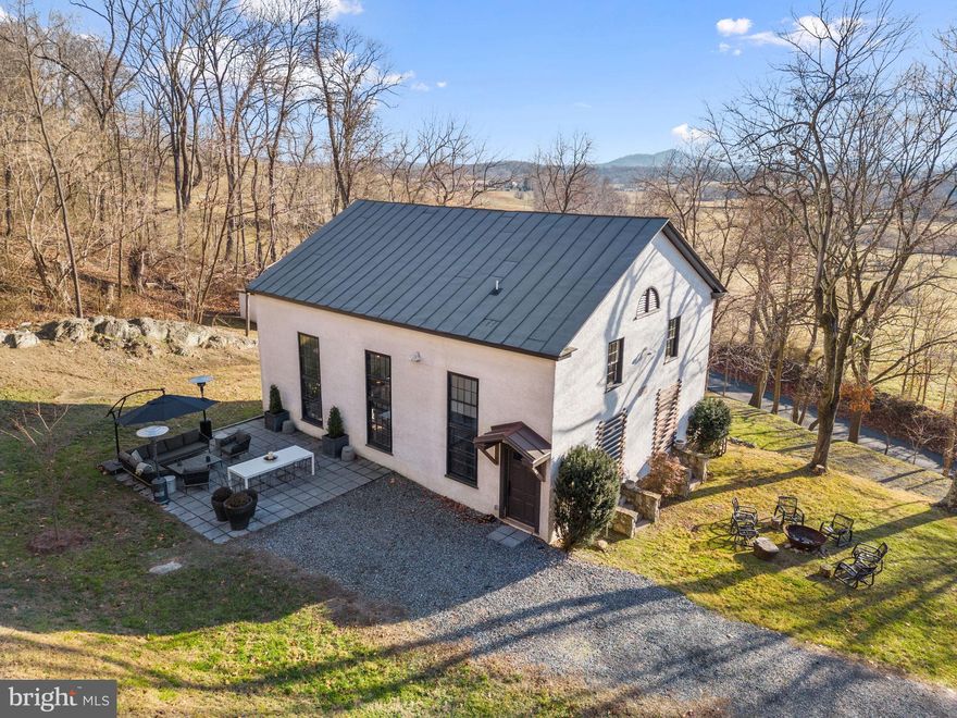 Discover a rare opportunity for idyllic serenity in picturesque Rappahannock County. Battle Run Church, originally built in 1832, has been thoughtfully converted into a stunning residence by a renowned Virginia hunt country interior designer. This remarkable property offers a perfect retreat on just 1.4 acres, yet is completely surrounded by the rolling hills of the historic Ben Venue Farm, which spans over 1,600 acres. The residence boasts 2 bedrooms (plus an office) and 2 baths, with living areas on two levels totaling over 2,000 square feet. The original sanctuary is now an expansive great room made for entertaining, with 17’ ceilings, multiple seating vignettes, dining space for 10+, and even room for a grand piano. The fully modern kitchen, with custom cabinetry made from salvaged wood and new Caeserstone quartz countertops, exudes both elegance and charm. For the homeowner, enjoy single-floor living with a main level primary bedroom and en suite bath, complete with a large shower and custom Elfa closets. Upstairs, guests will find a welcoming space with another bedroom and en suite bath, as well as a versatile office or third bedroom, offering inspiring work-from-home views. With all systems and appliances less than 5 years old, including HVAC and water heater, and a newly insulated attic for added efficiency, this residence seamlessly blends historic charm with modern convenience. Step outside and enjoy multiple areas for entertaining and relaxation, including a spacious stone terrace and a cozy firepit, offering breathtaking views of the surrounding fields and mountains. Just a short drive away, you'll find local favorites in Flint Hill, such as the Dark Horse Tavern and The Blue Door Kitchen, while Washington offers delightful dining options at Patty O’s Café and the world-renowned Inn at Little Washington. Embrace an outdoor-focused lifestyle with easy access to hiking in Shenandoah National Park and picnics along Skyline Drive, all within a scenic drive of only 1.5 hours to/from Washington, DC. Whether it's the ever-changing backdrop of the Rappahannock landscape or the proximity to charming cafes and galleries in Flint Hill, Washington, and Sperryville, this property invites you to savor the best of Virginia countryside living.  NOTE: The property is also available to purchase fully-furnished, including art and accessories! It is so turn key, you only need to bring your toothbrush!  Pre-offer inspections are welcome. Offers will be reviewed on Wed, Feb 28th.