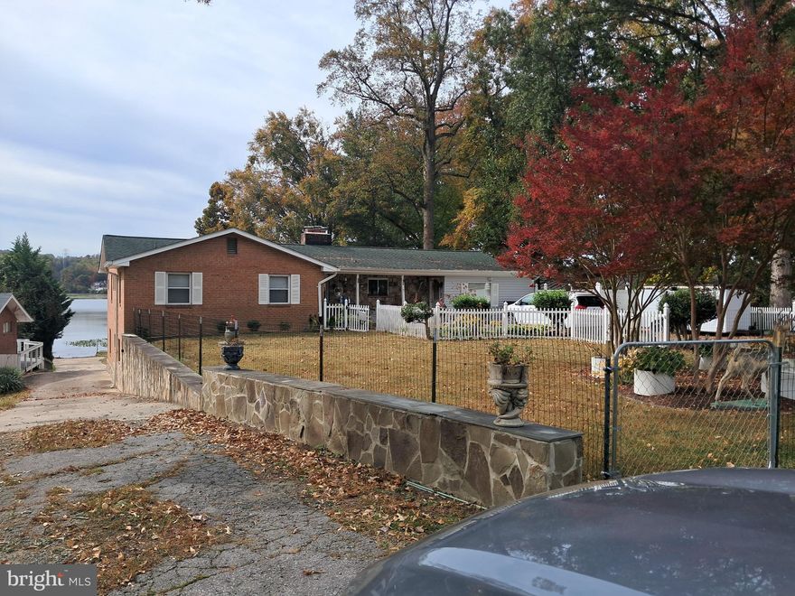 Quantico Creek Waterfront Property. Rarely does a property on the creek come on the market in the Possum Point Rd area. You can see the Potomac River from the property. Minuets from Quantico Marine base, VRE, and FBI facility and minuets to I95 North or South. Well maintained Brick rambler with large family room opening onto deck with great water view from the main level. Roof, kitchen & HVAC updated in  2017.  3 bedrooms, formal living room with fireplace, utility rooms and hobby room.  Lots of storage space thru out this house. Basement has a family room w/fireplace, second  laundry room. Large stroage area.Also features a Effiencey Apartment in the basement with private entrance rents for $1250 per month.Entrance is in the rear. Some furninshings can convey in apt. Seperate large garage in the rear of property . Was used as a large commercial workshop. There is also a building which at one time was a entertaing space ( Needs renovation). These buildings and the pool are all grandfathered (owner has County documentation on this) POOL AS IS has not been used in many years. New pool cover conveys. Apartment pictures will be added as weather permits today. All appliances in house convey including the apartment. It would be easy to remove walls and not have a rental if desired. More pictures when snow melts of interior and exterior