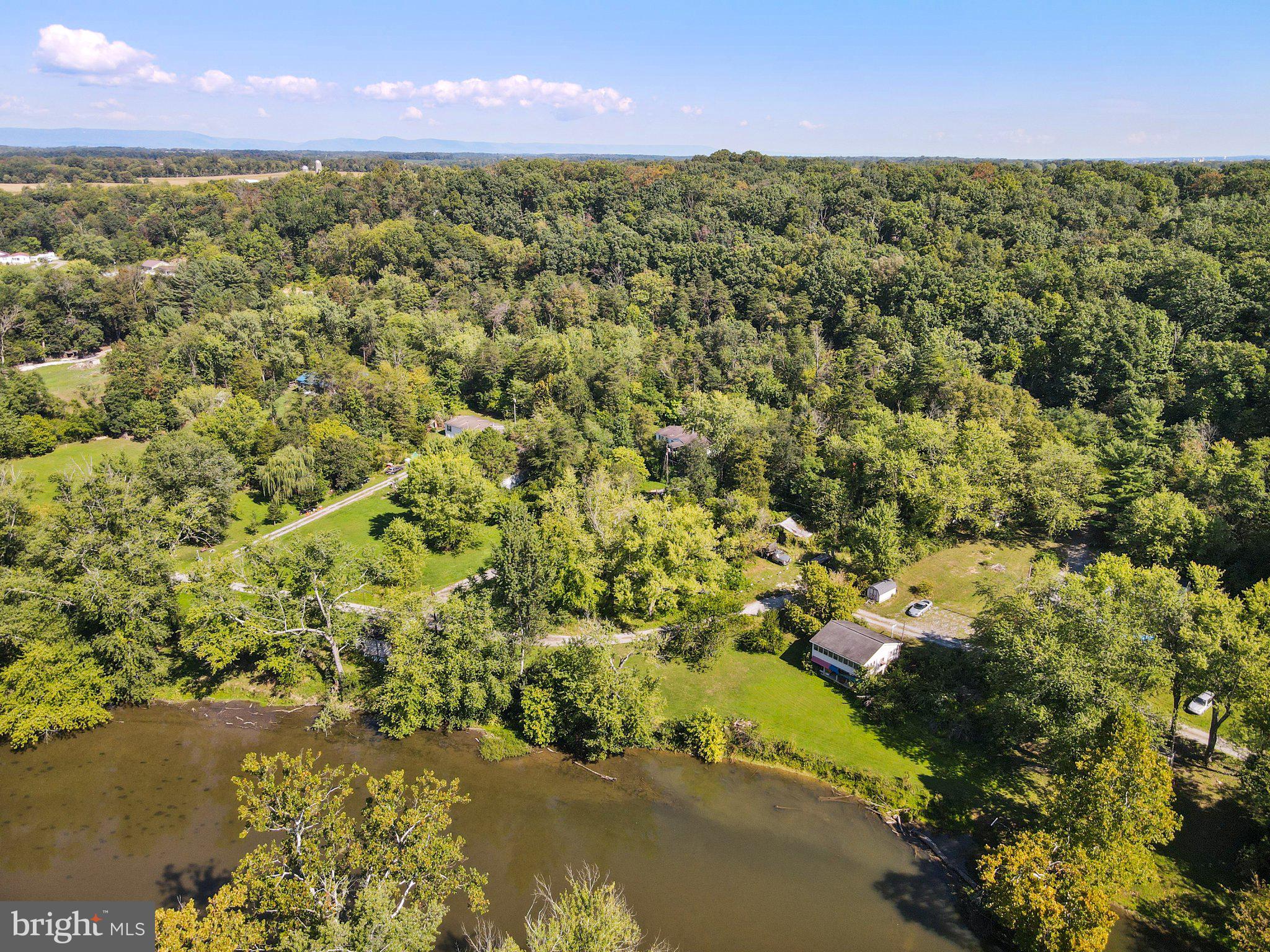Don’t miss this rare opportunity to own this 1.2-acre property nestled along the Conococheague Creek. Offering waterfront views and direct creek access—perfect for weekend getaways, outdoor enthusiasts, or those simply looking to escape the hustle and bustle. The lot features a primary home right along the water that needs some work. There are two additional outbuildings that would require major renovation or removal, but the lot offers great potential as a weekend retreat spot. With ample space, it's ideal for setting up a travel trailer or camper to enjoy the rural setting and creekside recreation. There is no existing bathroom, well, or septic system, and buyers are responsible for conducting their own due diligence regarding utility options and any future use. Property is being sold strictly as-is. Located in a flood zone. This is a great opportunity for someone looking to enjoy rural living and recreational land with direct creek access. Bring your vision—your private waterfront retreat awaits!