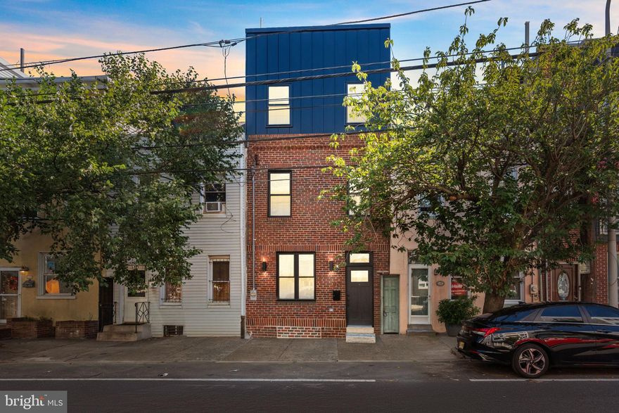 Welcome to 1321 N 2nd Street a brick-front masterpiece in the heart of Olde Kensington. This four-bedroom, two-and-a-half-bath home has been expanded with an additional level of living space, a full roof deck with 360-degree views of Center City Philadelphia, and luxury finishes throughout. The main level boasts 9’ ceilings, recessed lighting, and hardwood-style flooring flowing through a spacious family room with a custom accent wall and electric fireplace. A dedicated dining area leads into the chef’s kitchen, where sleek 36” white cabinetry pairs with a calacatta quartz waterfall island, high-end appliances, a motorized microwave, custom backsplash, chimney hood, matte black hardware, and statement pendant lighting. A half bath with touch-screen mirror and access to a massive backyard designed for entertaining complete this level. Custom open-riser stairs with night lighting and metal railings lead to the second floor, featuring two generously sized bedrooms, a full bath with a floating double-sink vanity, and a laundry room with built-in cabinetry. The third floor offers a full additional bedroom plus a private primary retreat highlighted by a custom trim accent wall, custom closets, and a spa-like bathroom with soaking tub, wet bed area, and oversized rain shower. This level also includes a stunning wet bar with a calacatta quartz waterfall counter, custom sink and shelving, and a built-in mini fridge—perfect for entertaining before heading upstairs. Continue upward to the roof deck, where you’ll enjoy breathtaking 360-degree views of Center City Philadelphia. A fully finished basement adds even more versatile living space, ideal for a home office, gym, or media room. This property truly has it all—modern design, thoughtful upgrades, and an unbeatable location. Make your appointment today.