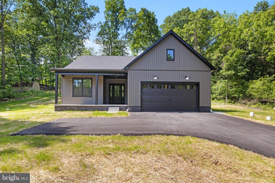 Why settle for dated finishes or builder-grade materials when you can own this beautifully crafted, custom-built home—brand new and move-in ready? Set on just over half an acre in the peaceful Carroll Valley countryside, this 3-bedroom, 2.5-bath modern rancher delivers both style and substance. Designed and built with long-term comfort and quality in mind, it features high-end finishes, energy-efficient systems, and thoughtful details throughout.

From the curb, the home stands out with its bold modern aesthetic: dark gray siding, black trim and windows, stained black columns, and a contrasting black front door—all offering a clean, non-traditional look that blends sleek design with country charm. Inside, you're welcomed by 9-foot ceilings, wide-plank luxury vinyl floors, and an open-concept layout perfect for everyday living or entertaining. The spacious living room boasts a dramatic 10-foot tray ceiling and flows into a bright, open kitchen complete with granite countertops, black appliances, soft-close cabinetry, and a large island with bar seating. A dedicated dining area overlooks the rear yard through oversized glass sliders.

The private primary suite features a vaulted ceiling, large walk-in closet, and an en-suite bathroom with a double vanity, step-in shower, and premium finishes. Two additional bedrooms and a full hall bath provide space for family, guests, or a home office. A conveniently located powder room and main-level laundry complete the floor plan.

The oversized 2-car garage offers ample room for vehicles, storage, or lawn equipment. A full basement presents an opportunity for future finished space—ideal for a rec room, gym, or guest suite. The home is equipped with a high-efficiency central HVAC system, modern lighting throughout, and brand-new utilities, including well and septic.

Other highlights include:

Asphalt driveway with turnaround
1st-floor laundry hookups
Energy-efficient vinyl windows
Granite countertops throughout
Quiet, established neighborhood 
Nearby Liberty Mountain Resort, golf, hiking, and commuter routes

Come see the difference a builder-owned home makes. Schedule your private tour today.