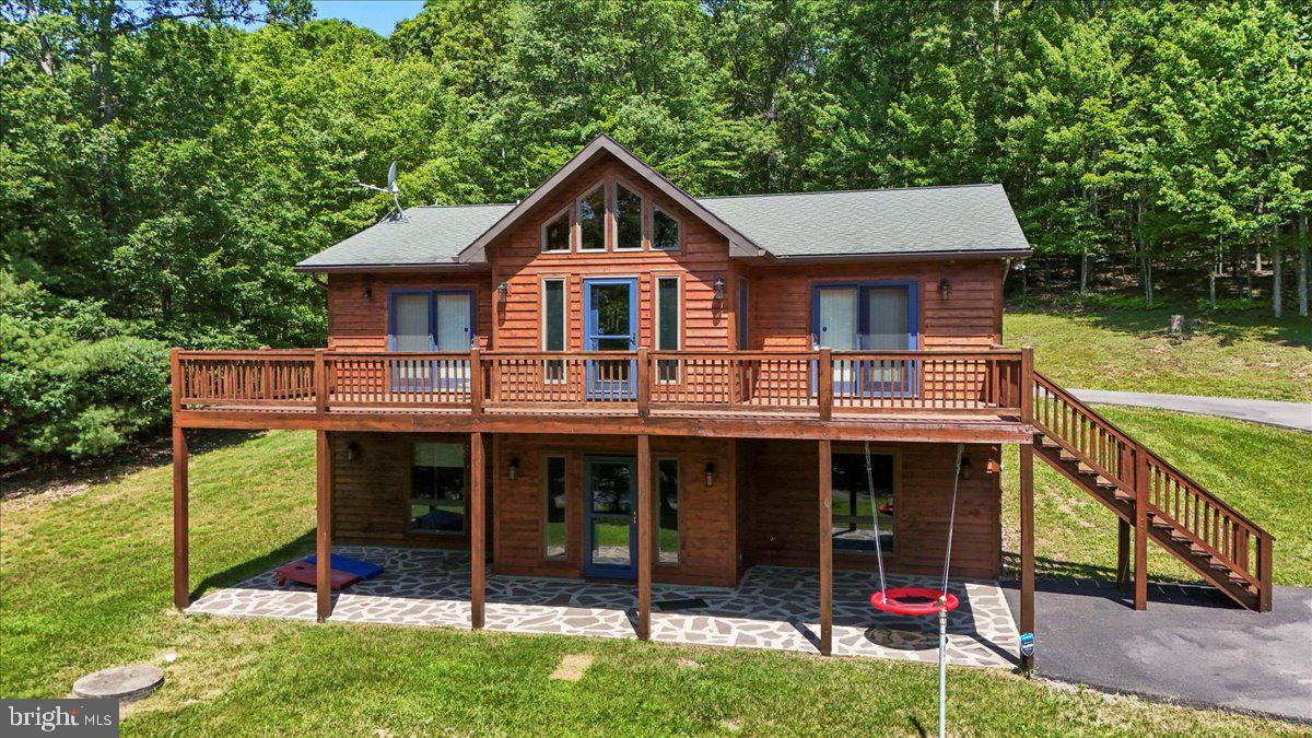 Welcome to 167 Sears Lane, a beautifully crafted A-Frame log home in Sun View Heights at Deep Creek Lake! This quality-built home has only been a private second home and not a rental property so it's been barely lived in and lovingly taken care of! It offers 2,688 finished square feet of living space, featuring 4 bedrooms and 3 full baths. Situated on a beautiful 1-acre lot surrounded by trees, this home provides the perfect balance of privacy and tranquility. As you step inside, you're greeted by soaring cathedral ceilings and an open floorplan, creating a bright and airy atmosphere. The main level boasts stunning wood floors, soaring ceilings and a spacious living room with a floor to ceiling local fieldstone gas fireplace, and a fully updated kitchen with crisp white cabinets and hickory accents, perfect for entertaining. Enjoy winter lake and mountain views from the expansive deck that spans the back of the home, accessible from both the living room and the main floor owner's suite.
The owner's suite is a retreat, complete with a slider to the deck, a luxurious ensuite bath with a soaking tub, separate shower, and double sinks. The finished lower level is an entertainer's dream with a large rec room featuring a pool table, recessed lighting, 9-foot ceilings, a wet bar, and a second fireplace with local fieldstone. Two additional bedrooms and a full bath complete this space, with direct access to the stone patio for year-round enjoyment.
The home is sold fully furnished, so you can move right in and start enjoying Deep Creek Lake living immediately! Recent updates include new carpet, central A/C, and a paved driveway added in 2023. The cedar exterior was professionally washed in 2023, and the minimal HOA fee of just $200 per year covers snow plowing for your convenience. A detached shed or garage provides extra storage space, while the big laundry room adds practicality to this fantastic home.
Located in a peaceful area, this home is a true mountain retreat, offering comfort, style, and the perfect setting for making lasting memories with family and friends. Just five minutes to the Thousand Acres Golf Course.