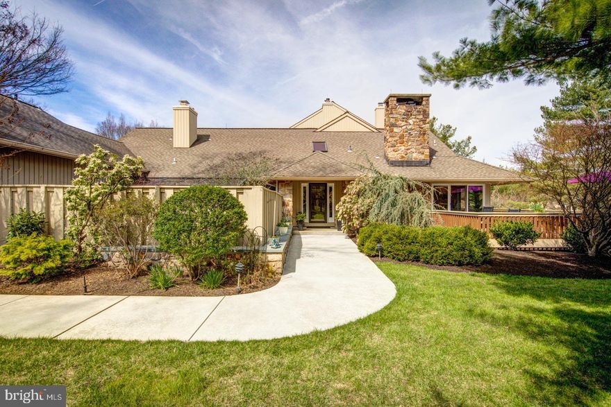 Situated in the coveted community of Hermitage, located on a private and beautifully landscape corner, welcome to the refined and spacious end-unit home. This home is a perfect blend of quality finishes, luxury, and comfort offering expansive living spaces in a serene environment. Stepping inside, the light-filled Entry hosts a dramatic barrel ceiling with a Limestone floor. Just beyond the entry, are beautiful Santos Mahogany wood floors on much of the first floor. The home has a tremendous open floor plan and flow! Additionally, most rooms have floor to ceiling glass flooding the home with natural sunlight. It has recently been repainted throughout in a fresh neutral palette.
To the left of the Entry is a handsome paneled Library with stately built-ins and a gas fireplace. Off the Library/Den is a cozy sun filled Greenhouse addition. To the right of the Entry is a Living Room, flooded with natural sunlight and a gas fireplace with a stunning Newly Custom Built Mantel with a slate surround. The Living Room opens to a wrap-around deck and a spacious Gourmet Chef’s Kitchen including: double Miele ovens, Bosch dishwasher, and Three Sub-Zero Refrigerators, a 5 burner gas Thermador cooktop. A massive Island adds additional prep space and seats four for casual dining & entertaining. This very noteworthy open floor plan includes a very sizable area for more formal dining which is open to the Kitchen, and glass doors leading to the vast Trex deck. 
The Gallery corridor off the Entry leads you past an elegant half bath and into the newly carpeted first floor Primary Suite. The Primary has both his & hers closets, and doors to a private terrace. The Primary Bath is designed with hand-carved woodwork, extensive cabinetry, marble flooring and walk-in shower, a soaking tub and a towel warming drawer.The remainder of the first floor hosts a 2nd sizable Bedroom ( currently used as an office ) and full Bath. There is also a sun-filled main floor Laundry Room and (2) car Garage on the main level. Above the garage is a 3rd En-Suite Bedroom and Full Bath. Don’t miss the very practical Dumb Waiter on the main floor to move clothing or luggage to the very convenient Fully Finished ( with heat & A/C ) Upper Level Storage including (2) cedar closets and a bank of additional closets & shelves.
Downstairs off the Kitchen is a voluminous Fully Finished Lower Level which is perfect for parties and game day! It has a gas fireplace, a Full Kitchen, a Full Bath and a new High-ended Audio/Visual System. There is a practical nearly whole house Generator. The home has a new Lutron Lighting System, (2) New Hot Water Heaters, a new furnace & A/C unit to name a few upgrades completed. Don’t miss this spectacular home!