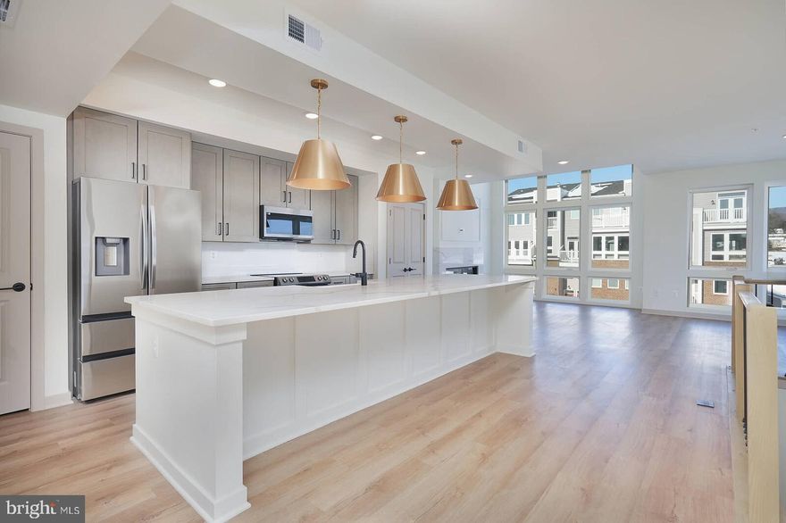 The seller is offering a $5,000 closing cost credit to the buyer with a ratified contract on or before 02/28/2026. Former builder model with over $35,000 in premium upgrades, this fully finished Napa model offers a compelling alternative to new construction. With more than 2,500 square feet across two levels, it is among the largest and most functional condo floorplans in the community, offering the space and feel of a townhome—or even a single-family home—without the maintenance.

Occupying the top two floors, the home is filled with natural light from windows on multiple sides and shares minimal common walls, providing exceptional privacy and an open, airy feel throughout.

The main level is designed for both everyday living and entertaining, featuring a wide-open layout that seamlessly connects the kitchen, dining, and family room. The kitchen includes a large center island, generous prep space, and room for a full dining table and comfortable seating area. A separate office or flex room on this level provides an ideal work-from-home setup without sacrificing bedroom space.

Upstairs, you’ll find three spacious bedrooms, two full baths, and a versatile loft well-suited for a second living area, playroom, or media space. Bedroom sizes exceed what is typically found in townhomes, making the layout practical for families, guests, or long-term flexibility.

Three private balconies/terraces add valuable outdoor living space. As the builder’s former model, the home features high-end finishes throughout, including luxury vinyl plank flooring, quartz countertops, upgraded appliances, custom trim details, a fireplace, and smart home features. The home is completely turnkey and has never been lived in.

Exterior maintenance, roof, and landscaping are handled by the condo association—offering the space of a townhome without the upkeep. Ideally located near I-70, I-270, Route 15, shopping, and downtown Frederick, this is a rare opportunity to own one of the largest and most upgraded homes in the community, now offered at an exceptional value.