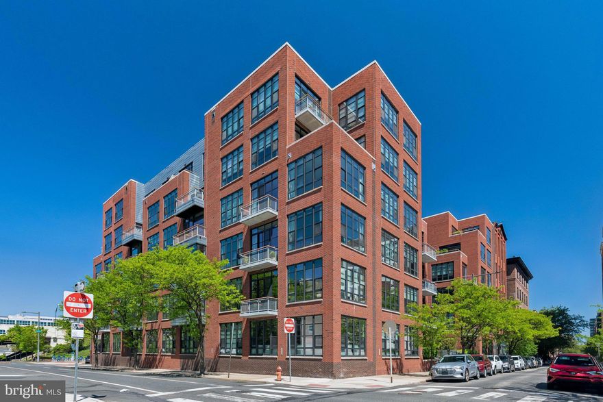 A rare offering at York Square Condominiums! This upgraded corner residence features two bedrooms, two baths, a private balcony, and the added bonus of 1 parking space.  Originally owned by developer Mark Hallowell, the home features elevated finishes throughout. The kitchen offers stainless steel appliances, upgraded granite countertops with a breakfast bar, and 42” cabinetry with glass accents. The primary suite has been beautifully renovated with a frameless glass shower, jacuzzi tub, and custom walk-in closet. With both southern and western exposures, the home is filled with natural light and showcases skyline views of Center City Philadelphia from the living area and primary bedroom. The spacious living room includes custom built-ins and a sleek media wall, ideal for entertaining.  Additional highlights include hardwood floors, 10-foot ceilings, oversized windows, a newer Bosch washer/dryer, private terrace, and a storage locker. York Square offers 24/7 concierge, a fitness center, and a resident lounge, all just moments from top dining, galleries, and easy access to I-676 and the Benjamin Franklin Bridge. A perfect blend of luxury, location, and convenience. 1 car garage parking included with the sale.