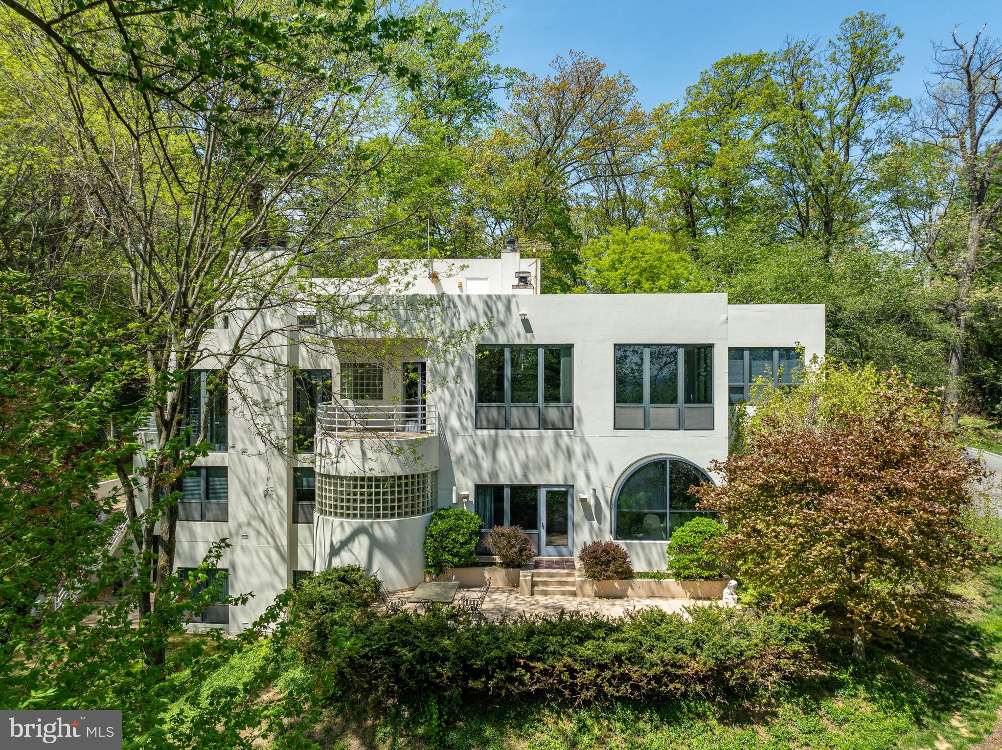 Welcome to this stunning contemporary masterpiece, custom-built by Bowser Construction, showcasing breathtaking architecture and a design that seamlessly blends luxury, functionality, and nature. Constructed with commercial-grade steel, cinderblock, and windows, this home offers unparalleled durability and style. Nestled on nearly 3 acres at the edge of the woods in a private and serene setting, the property is surrounded by nature’s beauty, with abundant wildlife and panoramic views through its extensive commercial grade windows. The open floor plan and soaring 29-foot ceilings in the great room create a bright and inviting atmosphere, perfect for entertaining or simply enjoying the tranquility of your surroundings. This expansive home features 5 bedrooms, 4 full bathrooms, and 4 half bathrooms, with custom finishes like extensive marble accents, abundant built-in planters, two spiral staircases, and several glass block windows that add a touch of modern elegance. The cozy living room boasts a wood fireplace and picturesque views of the woods, with an attached bar room ideal for hosting gatherings. The luxurious primary suite is a true retreat, featuring a tray ceiling, gas fireplace, sitting area, generous walk-in closet, and a tranquil en-suite bathroom with a jetted tub. Additional highlights include an indoor spa with a hot tub and a full bathroom, a gourmet kitchen with granite countertops and electric appliances, and a family room with another wood fireplace and an attached billiards/game room bathed in natural light. The fully finished basement offers versatile spaces, including an art studio, recreation room, and a theater room, providing endless opportunities for hobbies or relaxation. Located in a highly accessible area, this property is ideal for those seeking a blend of modern luxury, comfort, and a connection to nature. Don’t miss the opportunity to make this architectural gem your home!