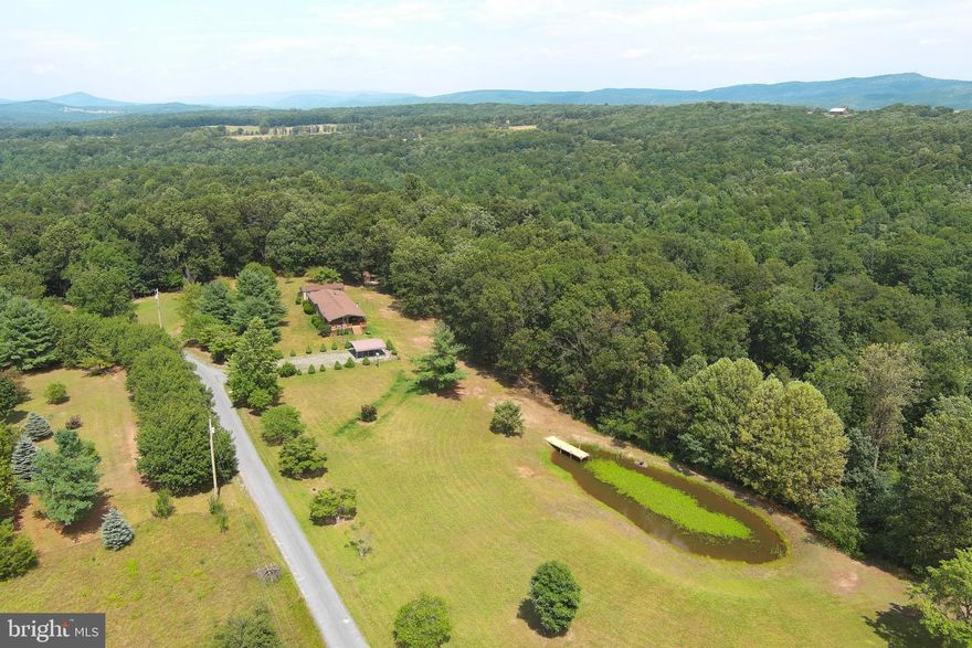 JUST REDUCED!!!  WHAT A VIEW!!! YOU WILL WANT TO SPEND ALL YOUR TIME OUT ON THE PORCH ENJOYING THE AWESOME VIEWS IN THIS QUIET, PARK-LIKE SETTING.  THE PROPERTY IS COMPRISED OF 2 LOTS, THE LOTS LAY NICE IN THE FRONT AND THEY SLOPE TO THE BACK TO A SMALL STREAM CLOSE TO THE BACK BOUNDARY; ATV TRAILS RUN THROUGH THE PROPERTY; 15 X 20  2-CAR CARPORT; MAGNIFICENT VIEWS OF THE MOUNTAINS, TREES & HUGE POND WITH DOCK AND FIRE PIT AREA.  RECENT UPDATES TO THIS LOG SIDED DOUBLE WIDE INCLUDE; NEW PAINT (INTERIOR  & EXTERIOR), MASTER BA HAS NEW TUB, NEW SINKS & NEW FLOORING THROUGHOUT.  THERE ARE 2 OUTBUILDINGS, THE  WORKSHOP(14 x 40) HAS ELECTRIC.  ONCE YOU GET HERE YOU MAY NOT WANT TO LEAVE!