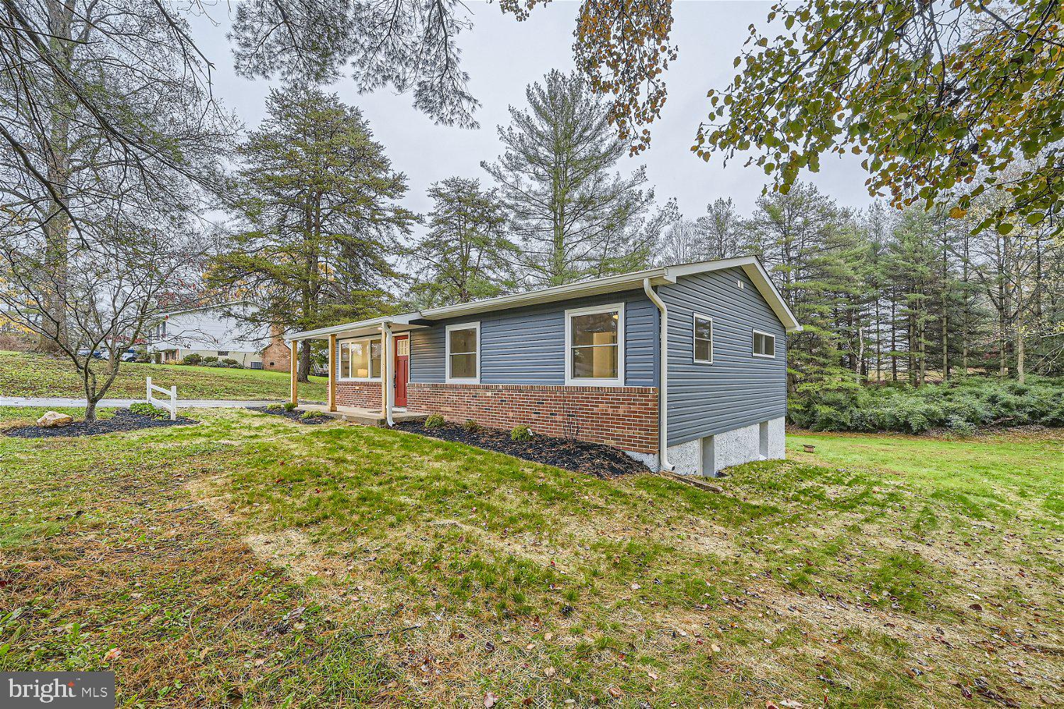 Beautifully remodeled 4BR/3BA Rancher on a sprawling lot in the quiet neighborhood of Sykesville. Pull up to this adorable home with tons of trees and greenspace, make your way to the covered front porch featuring wood columns, and open the door into your forever home. The interior has been completely transformed into open concept living with tons of features including board and batten, shiplap, stunning wood flooring, and plenty of upgrades throughout. The main living space offers a large open living room, spacious dining room and glamorous kitchen. Plenty of cabinets including a pantry and "uppers" to the ceiling, a deep stainless sink under a window, stainless steel appliances, sleek quartz countertops with a brilliant tiled backsplash, and for hosting family and friends, a large island with seating and beautiful lighting above. Down the hall is a large primary bedroom with a private full bath featuring a walk-in shower, two sizable secondary bedrooms, and a full bath. Additional living space on the carpeted lower level offers the fourth bedroom, a full bath, a wet bar, a large family room with space for everyone, and a walk-out to amazing yard space. From the kitchen step outside to a large patio that overlooks an abundance of green space and forest-like surrounding. This home is move-in ready with so much to offer new homeowners including recessed lighting, new carpeting and flooring, and ceiling fans throughout. Imagine all this and in close proximity to shopping, restaurants, and commuter routes.