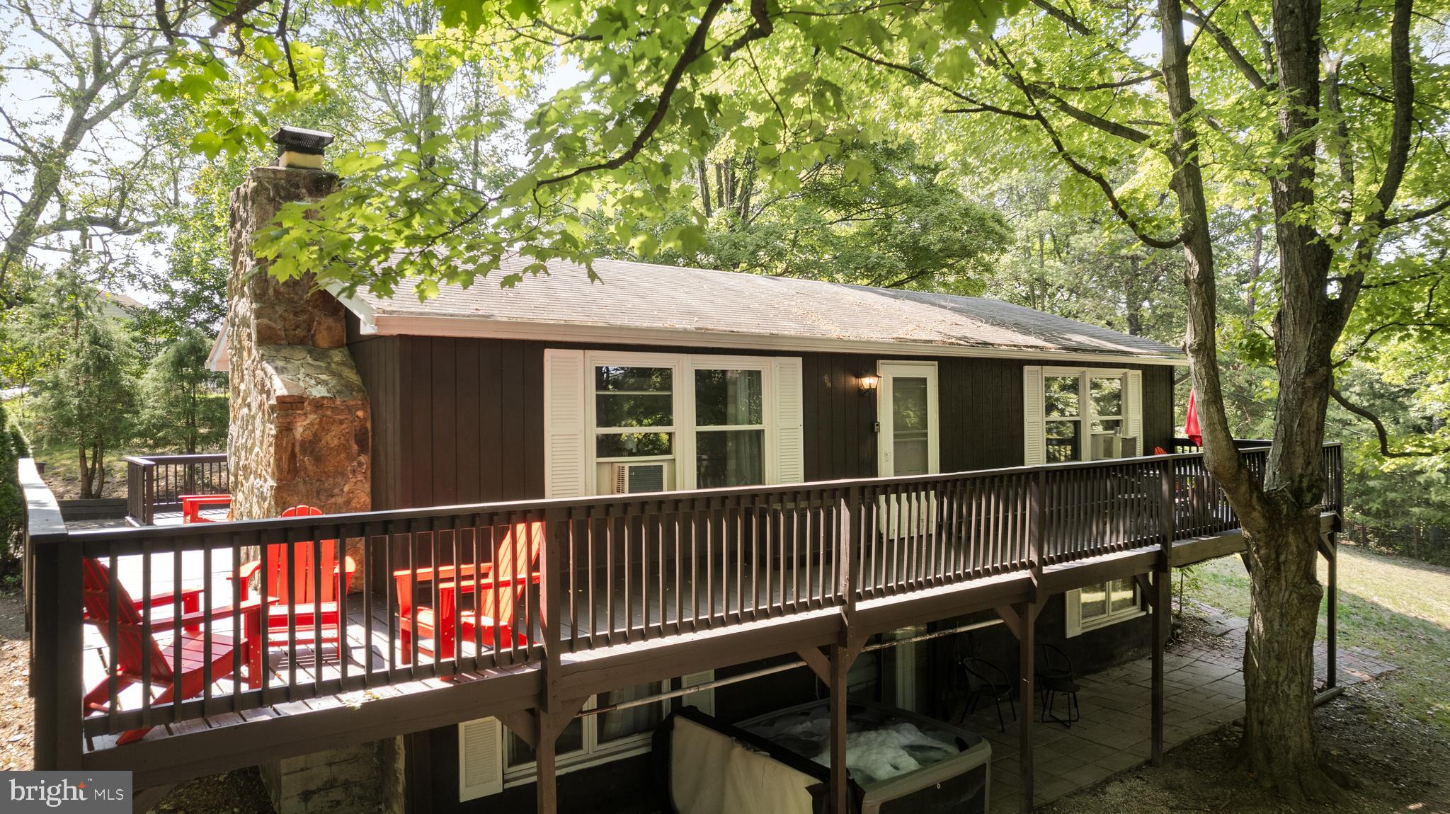 Large, four-bedroom cabin just minutes from downtown Berkeley Springs (less than a mile to the springs)! Newly renovated kitchen with stainless steel appliances, finished basement, wraparound deck, and a large yard. No HOA. Professionally designed with all new furniture, modern decor, and hot tub. Seller spent over $60,000 upgrading the property. As a vacation rental, it has generated $99,000 over the past 21 months, and can come with an existing property manager and cleaner.
Hot tub optional, available for purchase. See agent notes for summary of rental history and financials. $5,000 buyer credit if you continue using the same property manager. Perfect vacation home or investment property!
