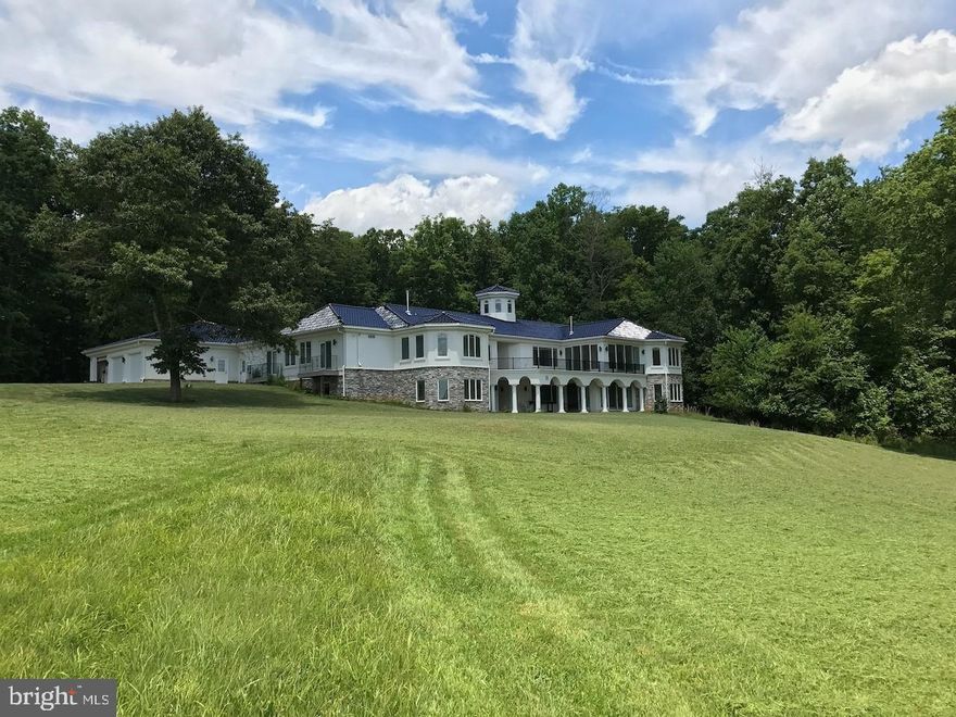 SELLER ACCEPTING BACK UP OFFERS Welcome to Meadowland! Step in to a magnificent custom built Mediterranean style estate home boasting over 9,100 finished square feet on two levels with a striking dark blue imported tile roof. This grand estate is perfectly situated on a partially wooded 18 acre parcel, second largest in the community and overlooking a glistening pond in which you own over 1,000 feet of water front. Circular drive brings you in under a large covered  portico. The moment you walk thru the arched glass front doors you will be captivated by the breathtaking water views and the light filled space from the 8 window center tower in the foyer. Your entry way is filled with Italian marble floors and  built in library which opens to the large lower level theater room below.  A true chefs kitchen appointed with professional commercial grade stainless cabinets, sleek black galaxy counter tops, 48" Subzero refrigerator and Wolf appliances plus butlers pantry and prep area. Opulent Owners wing is privately situated offering a spacious bathroom with an 8 foot walk in steam shower plus 5 shower heads/body washes.  Stunning walk in closet plus bonus closet for additional storage. This suite includes your own sun room with sweeping views of the water and access to a 600 square foot concrete deck with composite tiles. Fully finished lower level with luxury area for a home theater. Optional in-law suite with dedicated bath and relaxing views of the pond and pasture. Plus additional bedroom with full bathroom in lower level.   Custom 8x16 safe room with solid steel vault door. Additional finished space plumbed for a 2nd kitchen and large recreation space. Attached 3 car garage plus 700 square foot shop with a full bathroom and kitchenette. Perfect for a rental unit or workshop or home office.  Additional 1,000 square foot garage/barn for added storage or stable conversion.  This sophisticated home is not only sleek with a modern flare but its extremely energy efficient; SPF insulation, Dual open loop Geo Thermal heat pumps with 6 zones, with independent controls and a computerized well system with variant speed pump for equal water pressure. 800 amp service (400 for house and 400 for shop) plus High Speed Cable Internet available thru Comcast. This luxurious private estate is not only located with in a beautiful equestrian gated community but its conveniently located 15 mins to Park and Ride, 30 minutes to Fredericksburg and the VRE, 45 mins to downtown Charlottesville or Quantico and 1 hour to DC via express lanes.