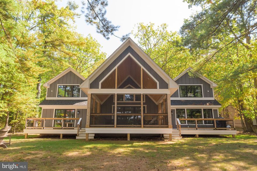 Stunning waterfront home with 101' of shoreline on Deep Creek Lake! This home was newly constructed in 2022 and is warm and inviting from the moment you enter. Offering two levels of spacious living space, an open floorplan, luxury vinyl flooring, stone wood burning fireplace, and an expansive kitchen island. The abundance of windows affords you the luxury of enjoying beautiful water views from almost every room. The enclosed porch and multiple decks are ideal for enjoying friends and family during any season. The bunk house provides additional sleeping quarters with a full bathroom. You will love the privacy and convenience of your type A dock permit, which is easily accessible from your level rear yard. This home won't last long, call today to preview!