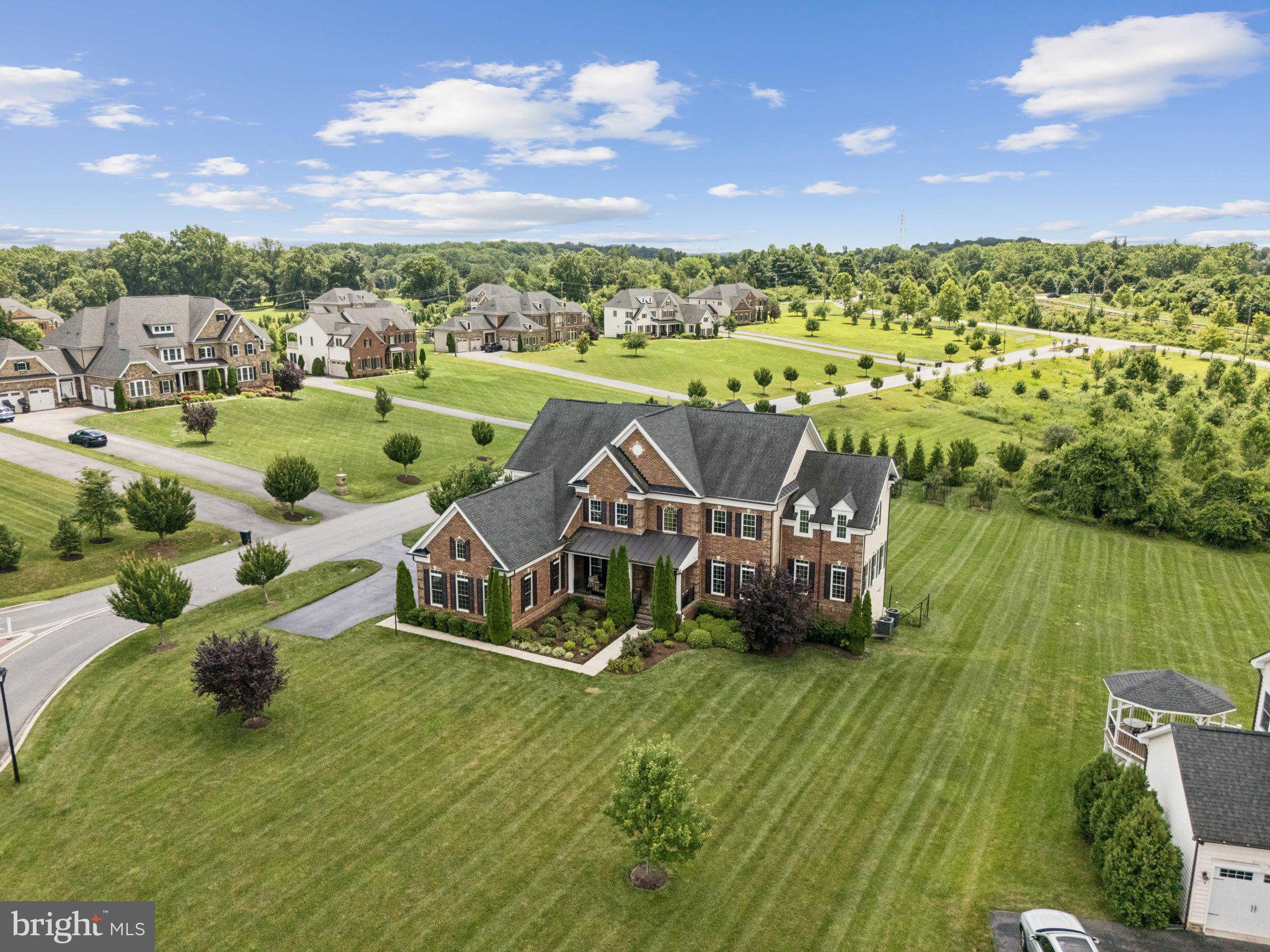 Welcome to 5025 Bee Frances Way, a stunning colonial masterpiece set on a premium 1-acre corner lot in the exclusive Greenberry community—an intimate enclave of just 25 estate homes built by NV Homes.
Constructed in 2016, this expansive residence offers approximately 9,000 square feet of finely crafted living space, including 7 spacious bedrooms and 6.5 bathrooms, perfectly suited for multi-generational living, elegant entertaining, and everyday luxury.
Enter through a dramatic two-story foyer, flanked by formal living and dining rooms. The heart of the home is the impressive two-story family room, flooded with natural light from floor-to-ceiling windows, and seamlessly connected to a gourmet eat-in kitchen featuring two oversized center islands, high-end appliances, and custom cabinetry.
Step outside to the covered rear porch overlooking a lushly landscaped backyard enhanced by mature trees and a mini fruit orchard—an ideal setting for relaxation or entertaining.
The main-level owner’s suite offers a tranquil retreat with a spa-like en suite bath. A second owner’s suite upstairs features a large sitting room, an oversized walk-in closet, and a private balcony with sweeping views of the grounds.
Additional highlights include:
+ A private home office with French doors
+ A functional mudroom with built-in storage, a walk-in pantry, and dedicated main-level laundry
+ A second upstairs laundry room for added convenience
+ A fully finished walk-out lower level with a 7th bedroom, expansive wet bar, full bathroom, home theater, and large recreation area
+ An attached 3-car side-load garage
Ideally located in one of Howard County’s most desirable neighborhoods, this exceptional home is just minutes from award-winning schools, shopping, and commuter routes to the greater Baltimore-Washington corridor.
Don’t miss your opportunity to own this extraordinary estate in Clarksville’s coveted Greenberry community—where luxury meets lifestyle.