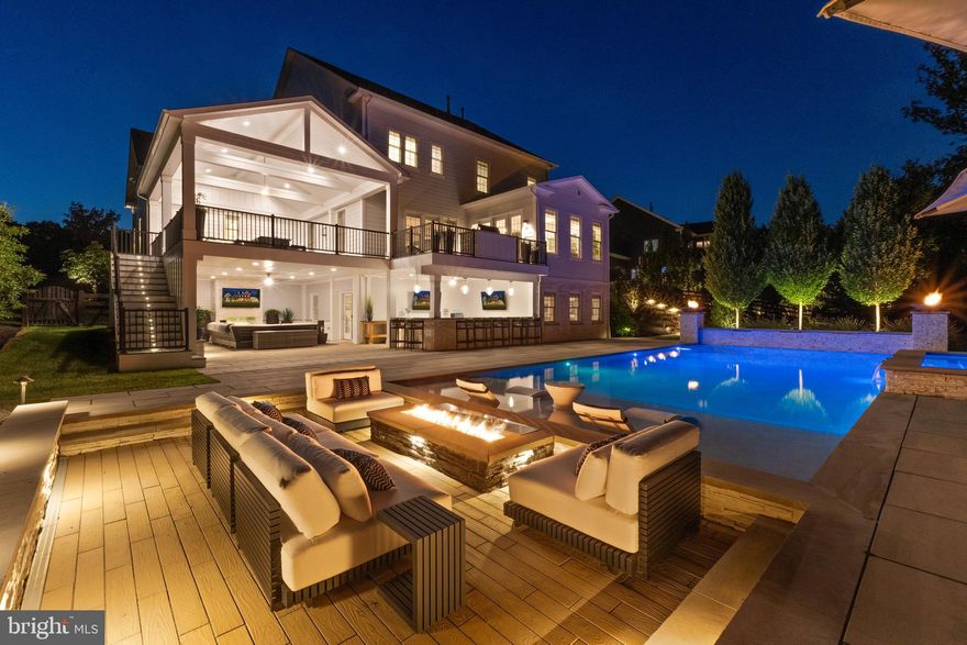 A breathtaking resort-caliber saltwater pool sets the tone for this extraordinary residence, delivering a true Ritz-Carlton–inspired experience in the comfort of your own backyard. Designed with a luxurious 7-foot depth and a premium soft-finish base, the pool invites both serene relaxation and elevated entertaining. A grand spa with cascading water feature and a striking designer ring fountain create a dramatic focal point, while evening uplighting transforms the entire setting into a private, five-star retreat.

Surrounding the pool, expansive custom hardscaping and a sleek track deck offer multiple spaces to lounge and gather—from elegant in-water loungers to a sunken conversation area centered around a modern fire feature. Dual fire bowls and a custom fire pit further enhance the ambiance, creating an atmosphere of warmth and sophistication reminiscent of the world’s finest resorts.

The outdoor living area continues seamlessly beneath the covered entertainment space, featuring a custom gas fireplace, a built-in natural gas grill, an outdoor refrigerator and ice maker, and all-weather TVs—perfectly designed for effortless hosting in every season. Thoughtful details, such as a Restoration Hardware umbrella and a premium outdoor fan, complete this refined outdoor environment.

Inside, the home carries forward the same elevated design with a brand new Luxury Vinyl floor, fresh designer paint, and upgraded lighting and fixtures throughout. A custom gas fireplace anchors the family room with modern elegance, while a desirable oversized main-level suite offers both flexibility and convenience for guests or multigenerational living. Custom craftsmanship is evident throughout, including coffered ceilings, a tray ceiling in the primary suite, detailed millwork, built-in office shelving, and a beautifully appointed butler’s pantry and mudroom.

Enhanced by a custom front entry, professionally designed landscaping, and a fully fenced yard, this home offers both striking curb appeal and peace of mind with updated major systems and appliances.

This is more than a home—it is a private retreat delivering a Ritz-Carlton lifestyle every day.

 This home sits in the award-winning Willowsford Community, surrounded by Loudoun’s wine country. Enjoy resort-style amenities—beach-entry pools, splash pad, lodge, fitness center, dog parks, sledding hill, tree house, and even a farm stand/CSA. Minutes from Brambleton and One Loudoun for dining, shopping, and entertainment, plus nearby Hanson Regional Park (257 acres!), farmers markets, Wegmans, wineries, and breweries. Convenient to Dulles Airport, Silver Line Metro, Tysons/DC, and top-rated Loudoun County schools.
