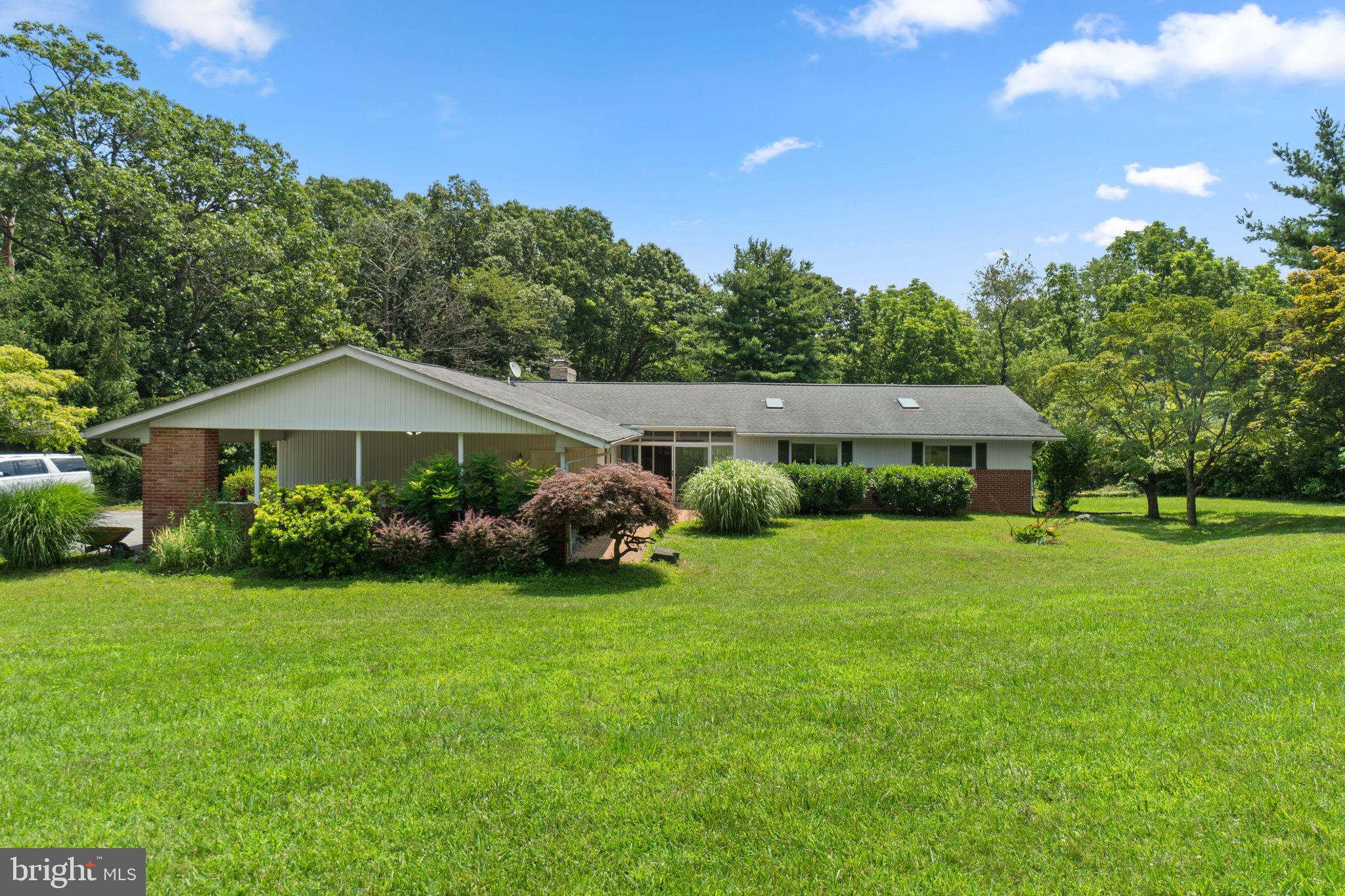 Home is occupied and under surveillance - do not enter property without appointment. Welcome to 6411 Ridge Road, a spacious and meticulously maintained home nestled on a serene lot in Mount Airy. Boasting 5 bedrooms and 3.5 bathrooms, this home offers a rare combination of functional space, thoughtful updates, and charming custom features—ideal for multigenerational living, hobbyists, and anyone seeking comfort and versatility. Step inside to discover a main level designed for both everyday living and entertaining. The bright kitchen includes a built-in BBQ grill, electric stove, pantry, and an adjoining family room with a cozy wood-burning fireplace and access to a private patio. A tile-floored bedroom just off the kitchen offers flexible use for guests or a home office, while the convenient half bath and mudroom/laundry area—with front-load washer and dryer—add everyday practicality. The primary suite is a true retreat, complete with a large walk-in closet, private deck, and a luxurious en-suite bathroom featuring heated floors, a custom tile shower, dual vanities, and a cedar closet with a sauna hookup. Down the hall, you'll find additional bedrooms with heated floors and a beautifully updated hall bath with a custom shower. The fully finished basement expands your living space dramatically, offering a large workshop or storage room with its own fireplace, a spacious rec room, a full bath, and a bedroom—ideal for guests, hobbies, or potential in-law space. The basement also includes built-in shelving, a utility sink, and a freezer that stays with the home. Additional highlights include five sealed wood-burning fireplaces, tile flooring in the living areas, a 10-year-old roof, 2015 HVAC, 2024 water heater, a well water treatment system, and a regularly serviced septic system (WRF & Son Plumbing). The property also features a carport and an attached garage, three closets with attic storage, and Ring security cameras that convey. The well is located at the back left of the house, with a well pump that's only 10 years old. From the thoughtful interior upgrades to the incredible amount of storage and workshop space, this home is truly one of a kind. Don’t miss your opportunity to own a property that offers both lifestyle and longevity—schedule your private tour of 6411 Ridge Road today!