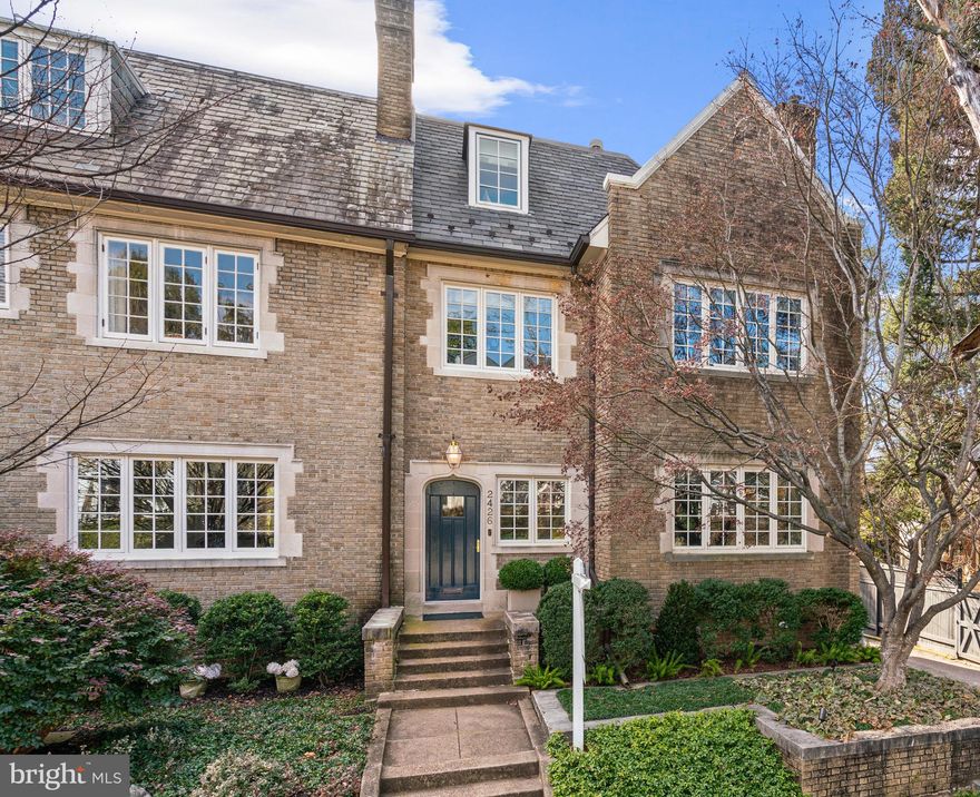 This rarely available Wardman end townhouse is desirably located in the distinguished Kalorama neighborhood, known primarily for being home to many diplomats, dignitaries, and other prominent Washingtonians. This impressive semi-detached residence was originally built in 1923 and has been beautifully updated. The house encompasses over 4,600 square feet of interior living space with generously-scaled formal entertaining rooms, as well a comfortable family living spaces. Stunning architectural details are found throughout including lovely archways, impressive columns, thick crown moldings, paneling, transom windows, and detailed fireplace mantles. The home captures an abundance of natural sunlight from exposures on three sides, which is further magnified by the large windows and high ceilings throughout. A gracious entry hall with marble floors seamlessly transitions to the sophisticated living room with a fireplace. The living room adjoins the formal dining room, which is framed by attractive columns. The gourmet kitchen is well-appointed with abundant cabinetry storage, stainless steel appliances, marble countertops, and a large center island with a breakfast bar. The kitchen opens to a sunny breakfast room and to the generous family room, both of which have French doors to the large wrap around covered terrace. There is also the added convenience of a powder room on this floor. An elegant staircase leads to the second level, which offers a large landing, flooded with sunlight from an overhead skylight. This level, which acts as a primary floor, includes the luxurious primary bedroom with a private balcony and an en-suite bathroom with dual vanities, a frameless glass shower, and separate soaking tub. There is also a lovely private sitting room/office on this floor with built-in bookshelves and a fireplace, as well as a secondary full bathroom and large closet. The top floor of the residence offers two additional bedrooms, both spacious and light-filled, and a hall bathroom. One of the bedrooms has a large private balcony with remarkable panoramic views of Washington. The fully finished lower level offers various rooms with great flexibility. There is an office with built-ins, a sitting room, secondary kitchen, bedroom, full bathroom, and a sauna. There is also a laundry area, ample storage space, two-garages, and walk-out access to a terrace/additional parking space. The exceptionally private wrap-around rear terrace is wonderful for entertaining with multiple seating areas, a charming pergola, and beautiful mature green surroundings. This spectacular residence is within close proximity to neighborhood parks, restaurants, and shops.