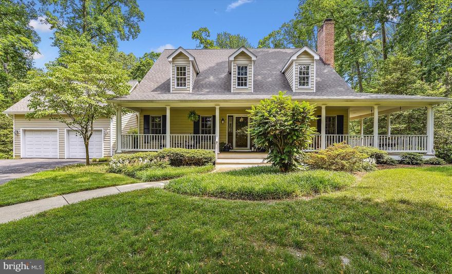 This custom built expanded Cape Cod is located in the stunning water privileged community of Stonington offering its residents wide tree lined streets, pier & slips, waterfront play, picnic & recreational areas and tennis|pickleball courts! Quality construction is apparent throughout all 5300+ SF and features 3 levels, 5 BR and 4.5 BA. This home is nestled off the main road and thoughtfully designed for large family gatherings highlighting the wide wrap around front porch and deck allowing full enjoyment of  the lush and very private landscaped grounds.  The main level features an open floor plan with gleaming hardwood floors with glitsa finish, oversized Living Room with wide hearth wood burning fireplace,  gracious Dining Room, large carpeted Main Level Bedroom Suite, eat-in Kitchen with solid wood cabinetry,  separate wine cabinet w/sink and loads of counter space on the cooktop center island,  and an additional half Bath.  Also on the main level is the tiled Sunroom with palladium windows allowing the afternoon sunlight to stream through the home. There is a long hallway to main level Laundry & access to the front load 2 car garage.  Kitchen, SunRoom and Dining Rooms all have French doors/sliders to large rear deck and grilling area.  The upper level features a Primary BR Suite with luxury tiled super Bath w/dual vanity, large walk in closet, separate shower & jetted tub, as well as 2 other sizable BR's that share a hall Bath.  The full lower level features huge Recreation Room area with sliders to the outside, Kitchenette  with center island, 5th BR and full Bath, and large unfinished workshop and office area. Additional features include architectural shingle roof replaced in 2021 with new gutters, updated dual zoned HVAC (17 and 5 yr) , water heater (4yr) all with warranties and an underground sprinkler.  There is a shared driveway with your neighbor with additional parking.
The is a fabulous property in a beautiful waterfront community in the  Broadneck School District and just minutes to Annapolis/USNA and the Chesapeake Bay! Easy access to 50/97 to Baltimore and DC.