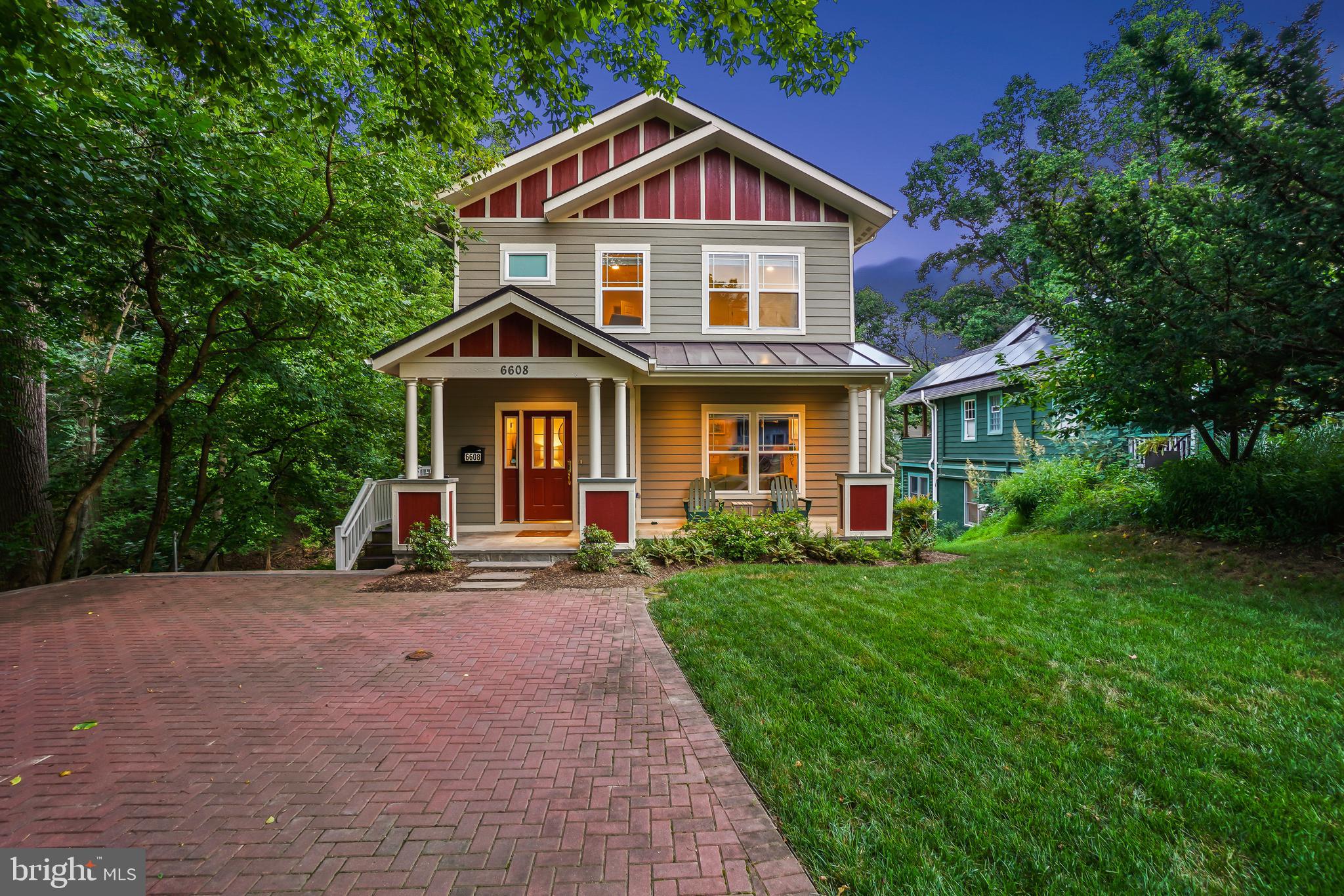Welcome to this extraordinary modern Craftsman Colonial, built in 2014, and perfectly situated in a picturesque setting beside the tranquil Takoma Branch Stream. From the moment you arrive, the soothing sounds of babbling water and the charming covered front porch create an irresistible first impression. This home combines natural beauty, thoughtful design, and an enviable location!
Inside, the open-concept layout is as versatile as it is stylish, offering beautifully proportioned rooms and a seamless flow for daily living, work, and entertaining. The home is filled with natural light and enhanced by rich hardwood flooring, classic trims, recessed LED lighting, and striking double-paned windows that frame scenic views and invite the outdoors in. A brick driveway leads to the inviting front porch, which opens into a warm and functional foyer with a coat closet.
The spacious living room features a wall of windows, a fireplace with glass doors, and a dramatic spoked chandelier. Adjacent is the open dining area, complete with an elongated modern farmhouse chandelier and room to host memorable gatherings. The chef’s kitchen is a dream—equipped with GE stainless steel appliance (with a Bosch dishwasher), granite countertops, a gas range, a center island, soft-close cabinetry, pendant and recessed lighting, a pantry, and a built-in desk area. The kitchen opens directly into the cozy family room, where French doors lead out to an amazing composite deck overlooking the stream. A sunny main-level bedroom and full bathroom complete this floor, perfect for guests or a quiet workspace.
Upstairs, three spacious bedrooms include a showstopping primary suite with wall-to-wall carpeting, custom blinds, a huge walk-in closet, and a serene en-suite bath. The spa-like bathroom offers a soaking tub with floor-mounted filler, glass-enclosed shower with bench seating and a niche, double vanity, and elegant marble hexagon tile flooring. Two additional bedrooms on this level each feature deep closets, charming, wallpapered accent walls, and recessed lighting. This level also includes a hall bathroom with a double vanity and a convenient laundry room.
The expansive walk-out lower level offers tremendous flexibility and function. Enjoy a large recreation room with a wet bar with two wine refrigerators and sleek cabinetry, a Jack-and-Jill full bathroom, a fifth bedroom or au pair suite, a gym or bonus room, and a large storage room.
The outdoor spaces of this home are equally enchanting. Relax on the front porch or unwind on the fabulous deck as you listen to the babbling stream below. A lower patio with pleasing pergola, and a flat, fenced backyard make the outdoor space perfect for entertaining play, or pets. The exterior is clad in durable Hardiplank siding. A private driveway provides ample parking and includes an EV charging station.
Ideally located in eclectic, community-minded Takoma Park, this home offers not just a place to live but a lifestyle to love. Enjoy block parties, Halloween parades, and the neighborhood’s beloved Turkey Fry tradition. All just moments from local gems like the Takoma Farmers Market, Cielo Rojo, Busboys and Poets, Takoma Urban Park, and more. We’ll see you there!
