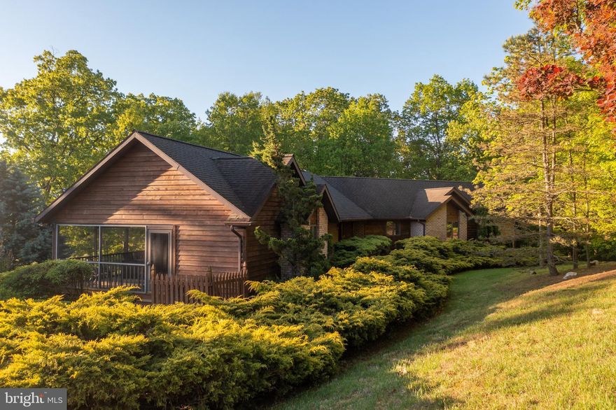 Custom Designed Natural Brick and Cedar Contemporary, just moments from historic Berkeley Springs WV. This spacious one owner home has only been used on weekends and shows as new. Pastoral Views great you as you enter the home through the many large Anderson windows,  Welcoming spacious floor plan, cathedral ceilings, stone fireplace, hickory flooring and cabinetry. Large screen porch with connecting study.  Relaxing on the screen porch viewing your natural gardens will help relieve the stress that's so common today.  Full unfinished lower level has may possibilities if extra space is needed. Truly a must see home, so book your appointment today!