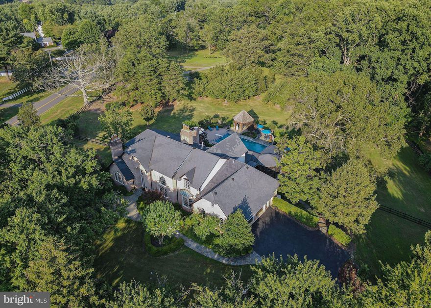 Your own private resort awaits you, welcome to 501 Scenic Way in pastoral Great Falls, Virginia.  Occupying 2.3 manicured acres, this estate blends elements of Tudor architecture with the classic Great Falls center-hall colonial aesthetic.  Whether seeking festivity or function, this home is certain to fit most any whim or desire.  Upon parking by the 3-car garage, you will marvel at the lush landscape as you approach the front entry leading to more than 8,000 finished square feet of luxury living.  With a flair for the formal, a handsome study greets you on the left, on the right- a grand formal living room with a two story ceiling, accented with extensive trim and moldings.  The kitchen & breakfast area open directly to a posh multi-level screened-in porch, with outdoor dining room, and comfortable living area with mounted tv, all overlooking the spectacular rear grounds.  The kitchen also flows into the formal dining room, via convenient butler's pantry.  As an added convenience, the owner's suite is situated on the main level, with a gas fireplace (one of 5 in the home), extensively built-out closets, grand bath with soaking-tub, separate shower, and an additional steam shower.  The main level is complimented with a walk-in pantry, and an accessory day-office that can be re-converted to a main-level laundry.The upper level sports 4 secondary bedrooms, three with ensuite baths, and a gallery overlooking the family room below.  The lower level offers an exceptional space for entertaining, including: a semi-enclosed zen garden with hot-tub, a changing room/pool-bath with convenient access to the outside, recreation room with wet bar & kitchenette, massive unfinished storage & main laundry, and a center for wellness equipped with cardio & resistance training equipment, and an adjacent day spa.  As sensational the interiors are, the outdoor experience at 501 Scenic Way will awe and inspire the active, while offering a peaceful sanctuary for relaxation & reflection.  The swimming pool has recently been converted to a saltwater-based system, with brand-new equipment including the pool heater.  The cascading lawns seem endless, tucked away behind the side perimeter fence.  Enjoy Summer evenings in the outdoor pavilion, with natural gas grill & accompanying refrigeration, and outdoor lounge area with a natural gas fireplace.  This retreat can be yours before the end of Summer, 501 Scenic Way is now available by appointment.  CDC guidelines apply for private tours.