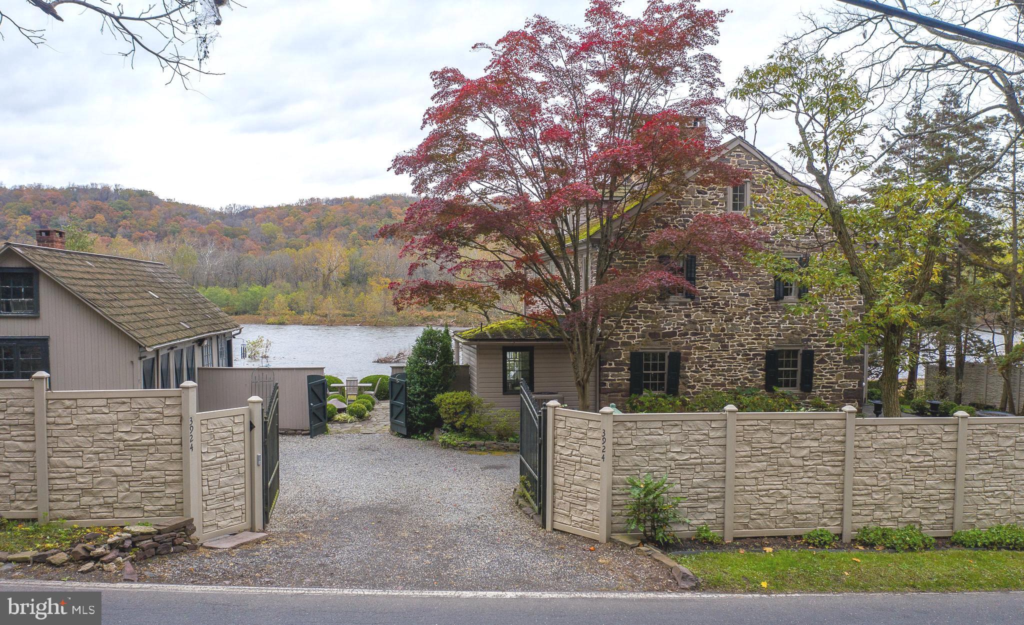 Come Enjoy A Little Piece Of Heaven! One of the prettiest waterfront homes, this majestic, (Circa 1740) lovely, stone country home, with separate carriage house, is the ideal weekend retreat! The captivating backdrop of the Delaware river, with unobstructed panoramic views, makes this hidden gem the perfect place to enjoy a relaxed lifestyle, in a quaint Bucks County town. Beyond the gated entrance, the aura of yesteryears comes alive. The home is a perfect blend of historic charm including high ceilings, original yellow pine flooring, 4 functioning fireplaces, tall sash windows and modern amenities, such as central air (New Unit 2020), 200 AMP electrical service (with all light switches using rheostats allowing you to set the lighting level), a water purification system, house generator (gas), updated appliances, and maintenance free gutters (with all gutters approved to drain into the canal). The main house has three full levels of living space with water views from many rooms. The ambiance begins the minute you walk through the doors of this premier home. The grand formal living room offers high ceilings, walk-in fireplace, beautiful pine floors and plenty of natural light. The main floor living space continues with a cozy parlor with fireplace, powder room, separate dining room, and kitchen. The updated kitchen offers granite counters, Vermont slate flooring, and stainless steel appliances. Just outside the kitchen, relax with a morning cup of "Joe" on the porchula (a covered area, 1/2 open pergola, 1/2 under roof), while enjoying the seasonal views of the outdoor space. The flow of the main level makes entertaining easy, with outdoor access to several patios and to the large screened in porch, with river views. A turned staircase leads you to the 2nd and 3rd bedroom quarters. The master bedroom suite is quite spacious and includes a full bath, fireplace and a sitting area, a great spot to enjoy a little quiet time. A full guest bath, spare bedroom and laundry room complete the 2nd floor. The versatile third floor space offers captivating views of the river and is quite large with dormer windows, window seating, built-in book shelves and generous closet space. Adding a shower to the existing third floor powder room could make this area a 2nd master suite, if needed. Outside, separated by a lovely courtyard with working fountain, is the picturesque carriage house, consisting of the garage spaces and private studio. Once the original "smokehouse", the studio has a functional walk-in fireplace with beautiful cypress flooring, an antique chandelier, ceiling fan and a new window, providing great views of the towpath and river. This home also has a basement with outside entry. Privacy abounds with the recent addition of a sound resistant composite faux stone fence, along the front of the home. The lush landscaped property is graced with formal boxwood gardens, flowering shrubs, stately trees, and perennial plantings. The pristine river setting and towpath, surrounded by stone walls, stone walkways, patios and the "whimsical" exterior lighting throughout the grounds, makes this a truly magical place to call home! Zoned VC, additional possibilities exist for the use of this property. Steel enforced concrete canal wall installed in 1995. Within walking distance to the Black Bass Hotel and Lumberville general store. Enjoy kayaking, canoeing, walking and biking along the towpath or take the beautiful ride along the river for a bit to downtown New Hope & Lambertville. Easy commute to NYC, Phila, Jersey Shore, and the Poconos. Affordable PA taxes.