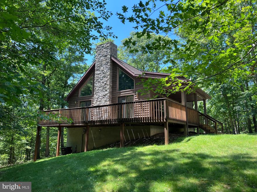 Welcome to 125 Highrock Trail, your private wooded retreat! Upon walking in the front door of this home you will immediately notice the stone fireplace that extends the height of the two-story ceiling, this is truly the focal point of the home. In addition to the magnificent fireplace the large open concept Living-Dining Room offers beautiful hardwood floors that extend back the hallway to where you will find the two bedrooms and one bathroom that are also located on the main level of the home. The spacious Primary Bedroom can be found on the second level of the home with an attached bath that features a jetted soaking tub, a separate shower, and dual vanities. The full unfinished basement is walkout level making for an easy storage space or could be finished for additional living space. Enjoy the private wooded setting of this home from the covered front or large side porch. The best part? This home comes FURNISHED! Just pack your bags and come ENJOY! Whether you are looking for a full or part-time residence this home is a MUST see!