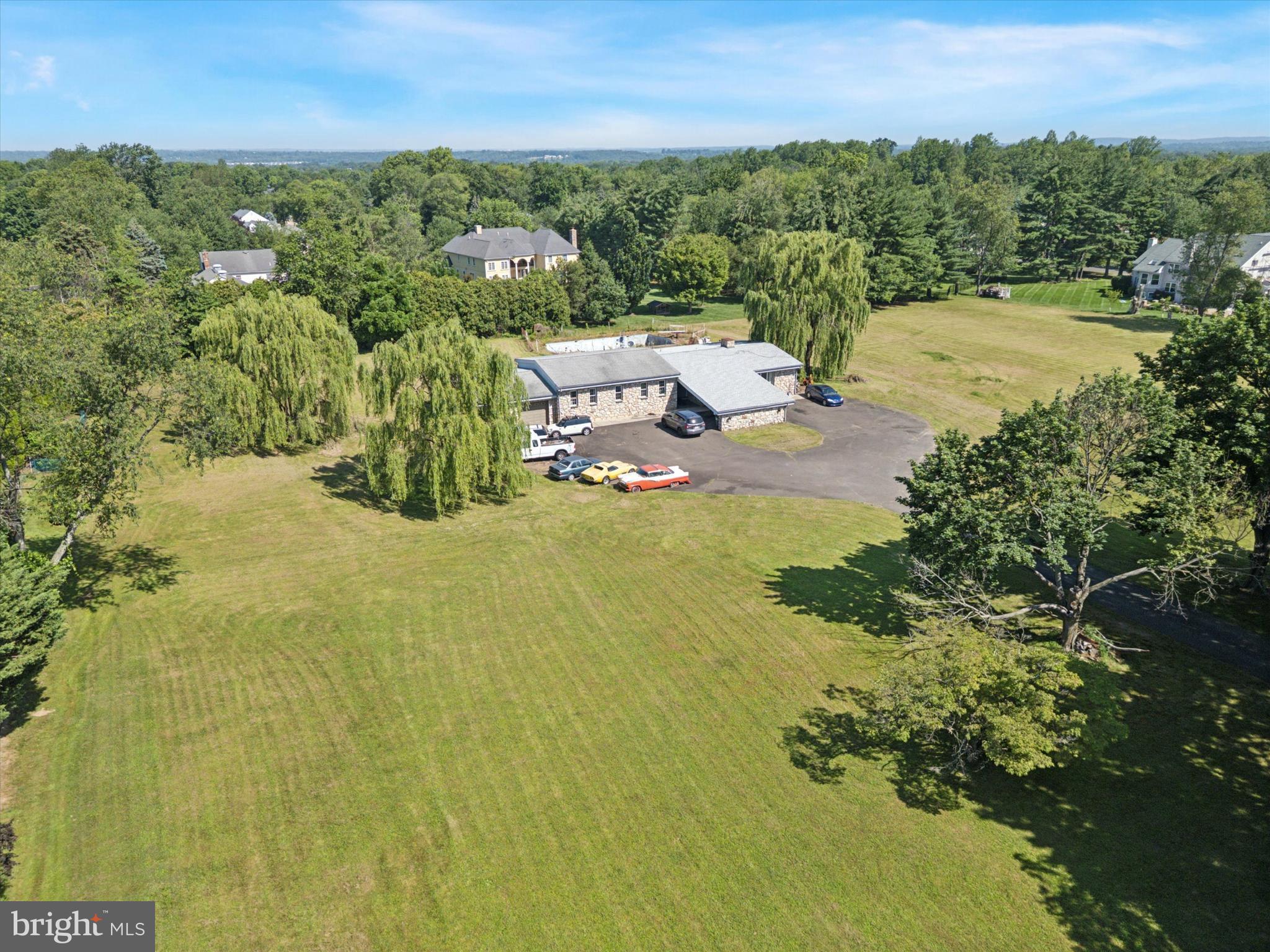 Your new home in Northampton Township just hit the market! Space abounds, inside and out, at this 6 bedroom, 5 bathroom Ranch home sitting on 3.1 acres. Set back from the road and surrounded by plentiful yard space, the property provides added peace and privacy. As you enter, you'll be greeted by an open living space beginning with the spacious family room showcasing hardwood flooring, stone fireplace centerpiece, and large window providing lots of natural light. The galley kitchen features plentiful cabinetry, electric cooktop and separate wall oven, and access to both dining areas for plentiful seating. There's also access to the large enclosed patio that includes a full bathroom and the laundry area. Down the hall to the sleeping quarters, begin with the spacious owner's suite including walkthrough bathroom featuring two sink vanities and dual closets. There are 2 additional bedrooms and hall bath with oversized dual sink vanity and tub shower. For even more usable space, head down the spiral staircase to the finished basement that includes open area with stone fireplace, 3 bedrooms or flex spaces for variable use, storage space, and 2 full bathrooms. Additional features of the home include central A/C, zoned electric heating, yard space in every direction, 2-car garage, and large circular driveway with porte-cochère. The home also has an in-ground pool, though it hasn't been used in many years and will need repair. Close proximity to Northampton Twp Municipal Park, Warminster Community Park, and Spring Mill Country Club! Don't miss your chance to own this fantastic property that offers so much to its next owner, with even greater potential possible!