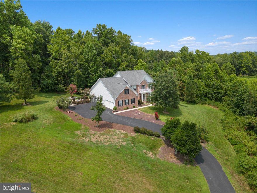 SIGNIFICANT PRICE ADJUSTMENT(priced BELOW recent appraised value)******HOME WARRANTY OFFERED*****This GORGEOUS Colonial home with 4 bedrooms, 3.5 baths and over 5800 finished square feet situated on 2.19 acres and backed to trees is PRICED TO SELL. Home features hardwood on the main level and upgraded berber carpet + padding in the primary bedroom. The primary bedroom is located on the main level and features remote-controlled blackout blinds and a spacious walk-in closet. Primary bath features dual vanities, soaking tub, water closet(enclosed toilet), and a newly renovated oversized shower. The spacious laundry room is located on the main level. Main level also features a two-story foyer, separate living room and dining room, serving area with cabinetry and wine rack. The kitchen opens to a two-story family room that features a gas fireplace and two-story windows with custom window treatments. An office with beautiful built-in cabinetry is located next to the family room. The second level features 3 generous sized bedrooms/closet spaces, full bath, and a view overlooking the two-story family room. Lower level is completely finished(Certificate of U&O can be provided). The impressive lower level features a wine cellar, gym(exercise equipment conveys w/acceptable offer), family room with bar/serving area, granite countertop sink, SS refrigerator, a full bath with a generous sized shower + rainfall shower head, and a flex room(perfect for a 5th bedroom or a second office) that connects to the full bath. Two sump pumps are located on the lower level.

Walk out the lower level to a beautiful rear yard adorned with brick pavers and up the stairs to an oversized maintenance-free deck. Newer roof, A/C, Septic Pump, and Well pump. Looking for a SMART home? This house features a voice activated system throughout  - compatible with Google Home and Alexa. If you enjoy fruit, take a short walk outside and enjoy some fruit from the peach tree(located on the side of the property) and the pear tree(located in front near the driveway). For those gardening enthusiasts, there is a special area in the back for you! This home will NOT disappoint - rural living at its finest!