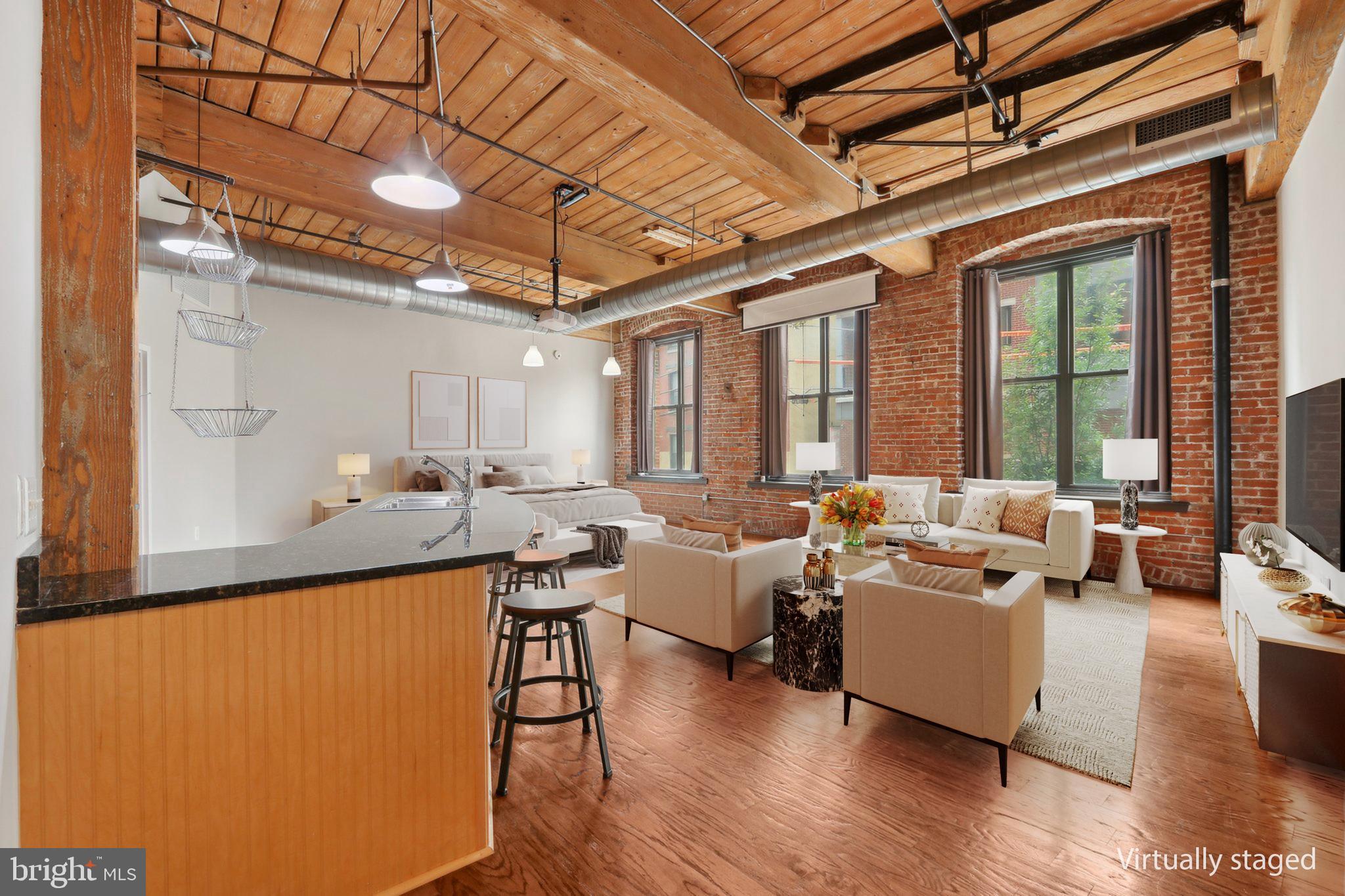Welcome to this stunning studio loft located in the highly sought-after Cigar Factory Condominiums, right in the heart of vibrant Northern Liberties! This unique and beautifully maintained unit offers the perfect blend of industrial charm and modern convenience. Enter inside and be greeted by soaring lofted ceilings and expansive windows that flood the space with natural light. The open layout showcases gleaming hardwood floors and an authentic industrial vibe that sets this unit apart. The kitchen is both functional and stylish, featuring stainless steel appliances, ample cabinet and counter space, and a breakfast bar with seating. A large walk-in closet offers generous storage and conveniently houses a stackable washer and dryer. The full bathroom includes a tub/shower combo and floating shelves for added storage. Every inch of this space has been thoughtfully designed for comfort and utility. Enjoy peace of mind in this secure building, complete with a rooftop lounge area, a secure mail room, and one deeded parking space in the attached garage—making city living truly hassle-free. Located in the heart of Northern Liberties, you're only blocks from restaurants, cafés, shops, public transportation, and with easy access to I-95, this condo puts everything you need right at your doorstep. Don’t miss this rare opportunity to own a piece of character and convenience in one of Philadelphia’s most desirable neighborhoods!