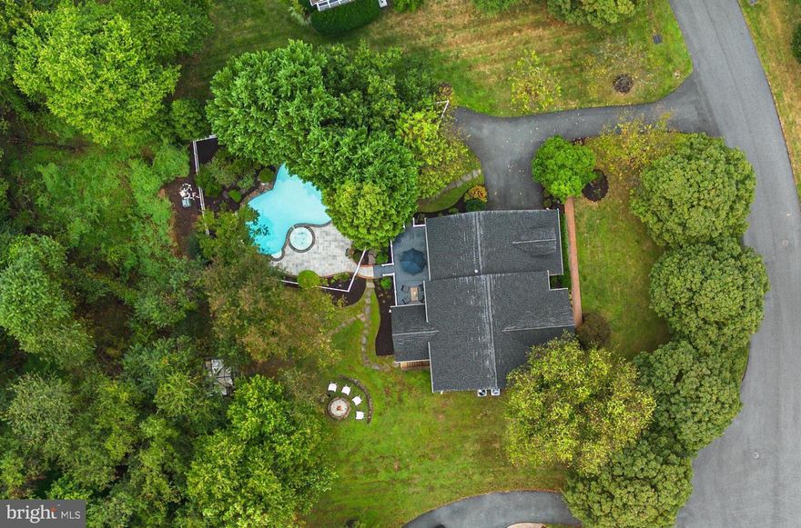 Welcome to The Kingsway Haven, a remarkable residence showcasing an array of indoor and outdoor spaces curated for luxurious living. Completely reimagined and thoughtfully renovated in 2022, this property is truly a haven for clean living with refined upgrades and wellness-driven design. The home backs to forest preserve and is tucked on a 0.7-acre homesite on a quiet cul-de-sac in the desired Kingsbridge community in Howard County’s Centennial School District. This prime location in Ellicott City is convenient to dining, shopping, parks, schools, country clubs, commuter routes, BWI airport, and more.

Exterior amenities reflect a resort-style sanctuary. A Trex® deck invites al fresco dining, and overlooks a fenced saltwater pool and spa surrounded by a stone patio and mature landscaping. Meandering stepping-stone pathways lead to the custom garden house or art studio, the stacked stone fire pit area, and the spectacular imported Belgian Orangerie—a truly dreamy space for growing plants, cozying up with a morning coffee, or hosting magical starlit dinners.

Inside, hand-sanded oiled oak floors, bespoke built-ins, and soaring windows fill the interior with natural light and elegance. A two-story foyer with a sparkling chandelier opens to the formal living room and the formal dining room with custom inlay floors, wainscoting and dentil mouldings, a tray ceiling, and chandelier. Ahead, the two-story great room unfolds, defined by elegant columns, vaulted ceilings, and a marble mosaic fireplace framed by treetop views through dramatic windows. Continue and find a chic powder room and a study with French doors, elegant mouldings, built-ins, and a bay window.

The English-inspired kitchen is a chef’s dream equipped with imported marble mosaics on walls and backsplash, Italian parquet tile floors, an oversized tiered quartz island with breakfast bar seating, rich cabinetry, pendant lighting, and an appliance suite including a Gaggenau® plumbed steam oven, Thermador® 5-burner range, Elica® designer hood, and Bosch® 800 Series refrigerator, oven, and dishwasher. An English café station with a built-in coffee bar and a custom English pantry complete this gourmet space, along with a breakfast area which accesses the deck. Just beyond, a mudroom features built-in cubbies, a built-in laundry station, cabinetry, plus a shower or dogwash station providing practical convenience for days spent enjoying the pool and outdoors.

Upstairs, rich hardwoods grace the floors and hallway leading to the Cotswolds-inspired primary suite. This serene retreat boasts two cedar walk-in closets, a tray ceiling, and a sitting room with columns and custom built-ins. The spa-like bath offers indulgent amenities: a copper soaking tub, a steam shower, a dual-sink vanity, a fireplace, a linen closet, and built-in shelving. Three additional bedrooms and beautiful bathrooms complete the upper level—including one with a whimsical built-in reading nook. A secondary rear staircase leads down to the kitchen.

Downstairs, the finished lower level is highlighted by wide-plank oak floors, a recreation lounge anchored by a stone-surround fireplace with built-in bookcases, and several defined spaces perfect for dining, entertaining, or playing. A versatile bonus room, a full bath, a walkup to the yard, and a fitness or yoga studio with mirrored walls and built-ins complete this spacious level.

This home was updated in 2022 with extensive and expensive upgrades including all new HardiePlank siding and trim, bronze gutters with integrated gutter guards, roof with CertainTeed Landmark Pro Designer architectural shingles with advanced underlayment and flashing, all new shutters throughout, a new Trane HVAC system, a whole-house air filter and humidifier, and a new cast iron sump pump. Move right in and immediately enjoy the wonderful turn-key value and lifestyle.

This is more than a residence—it’s a haven for elevated living. Let your new memories begin!