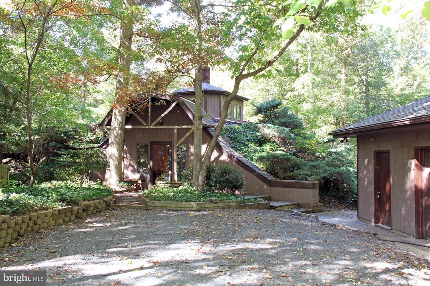 Are you looking for a perfect Air B and B? Come and see this amazing earth sheltered home in Hollywood, MD. Its dome construction, and earth covered surfaces provide for great durability and thermal insulation, keeping temperatures cooler in the summer and warmer in the winter. With both a fireplace in the master bedroom and a wood stove in the open kitchen, dining and living room area. When you first walk into this amazing 3 bedroom, 2 and 1/2 bathroom home from the front door on the main level, your eyes focus on the curved archways, tall brick chimney, and spiral staircase leading up to the 3rd level cupola where natural rays of light shine down from windows above. The circular construction provides several convenient areas for storage and closet space in the various rooms and along  the walls. As you walk in, you have a staircase leading to the lower level while up ahead and to your left and further in, beyond a full bathroom, you have two bedrooms, one to the left of the cupola and one to the right. Both bedrooms have individual outside balconies overlooking the wooden deck and hot tub below as-is) and natures wooded forest canopy all around as you experience the peaceful serenity and sounds of wildlife. Two separate staircases, one near the main entrance and one beyond the cupola, lead you down to the lower level open floor plan with large dining and living area. Nice kitchen with bar stool seating area, a half bathroom, and additional room area beyond the dining room. Master bedroom has a walk-in closet connecting to the master bathroom along with a lovely fireplace and additional storage closet. Both the master bedroom and living room have sliding glass doors that open up to the large wooden deck with hot tub and porch swing. Deck wraps up and around the house to main entrance and detached garage with climate-controlled area separated from car bay. Other side of the house has path and steps leading up to roof and cupola windows. Explore the over 3 and 3/4 acres of property with boarded pathway down to a dry stream bed which leads to Cuckold Creek and eventually out to the Patuxent River. The HOA includes access to the community pier. For an additional fee you can rent slip space for your boat. Property appraisal calculated square footage at 2568 square feet, which is over 400 square feet above the current tax record. You will have an easy commute to Patuxent River Naval Air Station and several businesses. Drive or bike ride to nearby shopping, restaurants and entertainment. Unique homes require unique financing and we have the lenders.  The seller provided the school information and the room measurements. Blueprints are available to review. Make this unique house your home today. The open floor plan is great for parties yet there are quiet spots where you can just sit and read a book. The property is wooded and secluded in a serene and peaceful neighborhood. There is a loop trail in the back that passes by a small creek. Enjoy sitting around the fire pit in the backyard at night and watching the stars. The energy efficiency of the house is a bonus.