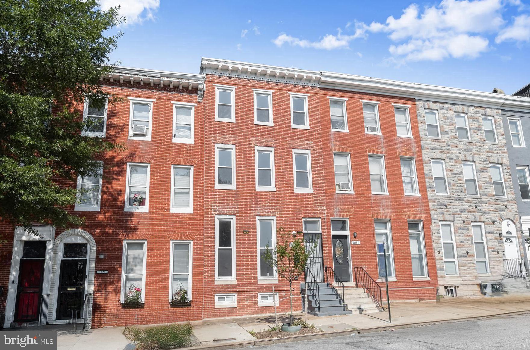 Welcome to this beautifully maintained brick townhome nestled in the charming Hopkins neighborhood of Baltimore City! Blending timeless 1913 architecture with thoughtful modern updates, this residence offers the perfect combination of character, comfort, and convenience. Ideally located near local parks and just minutes from downtown and Fells Point, you'll enjoy easy access to some of the city's best dining, shopping, and entertainment.  Step inside to discover an inviting open floor plan with soaring ceilings and sun-drenched hardwood floors that create a warm and welcoming atmosphere. The spacious living and dining areas are ideal for both everyday living and entertaining. The well-appointed kitchen features granite countertops, stainless steel appliances, ample cabinetry, and ceramic tile flooring that continues into a full bath and a main-level bedroom, perfect for guests or a home office.  Upstairs, the serene penthouse-level primary suite features plush carpeting, a walk-in closet, a calming neutral color palette, and an en-suite bathroom for a truly private experience. Three additional bedrooms, a full hall bath, and convenient upper-level laundry provide space and flexibility for the whole household. The lower level includes both interior access and walk-out stairs, with ample room to customize as a rec room, gym, home theater, or additional storage space.  On-street parking, a vibrant neighborhood feel, and proximity to commuter routes, including I-95, I-695, and I-83, make this home as practical as it is charming. Whether you’re relaxing at home, exploring the city, or hosting friends and family, this townhome is the perfect backdrop for your next chapter. Don’t miss your chance to make it yours!