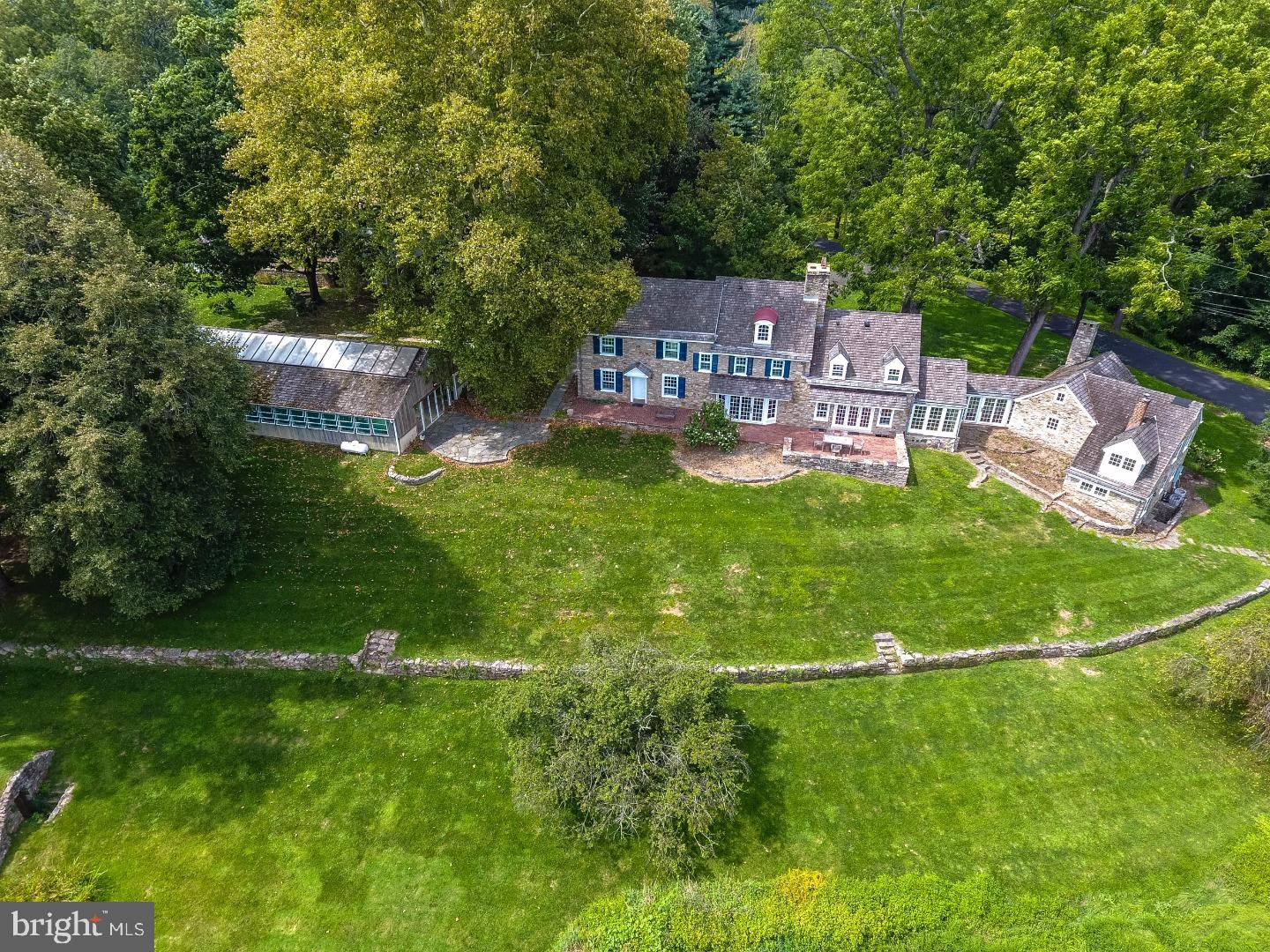 This picturesque estate reminiscent of an English country Gentleman's Farm epitomizes quintessential Bucks County. Much admired, the estate is situated on two of the prettiest roads in the county and is beautifully designed to cascade into the hillside. Its location atop the hill & its abundance of windows fills the house with light & allows for commanding views of the valley below. Not just beautiful, the property offers a rare opportunity to own a piece of history. With keystones dating the home to 1731 and the barn to 1728, the original buildings pre-date the American Revolution. Additions & updates have been made over the years with attention to detail & a conscious effort to maintain the integrity & stately beauty of this extraordinary home. Random width pumpkin pine & oak flooring has been re-finished to its original luster. Exposed beams and herring bone brick floors in the tavern room are a perfect complement to the huge stone fireplace. The carriage house, offering a retreat for guests, in-laws or au pair, is attached to the main house by a glassed-in breeze way and features one of the homes' 5 en-suite bedrooms, a family room with fireplace, office & library with built-in bookshelves. Other features of the main house include kitchen with custom cherry cabinets & butcher-block counters, gracious living room w/ fireplace, master bedroom w/ custom bathroom. The stone bank barn is a particularly lovely replica of barns found in England's Lake District and features a light-filled, 2 story, studio, guest quarters, original horse stalls, feed bins and original barn space is great for country parties! Indoor pool has adjoining entertaining area, laundry facility, 3 showers & kitchenette. Walled potagere kitchen garden w/ raised beds, chicken coop, 2 paddocks, pond, stream and spring house complete this spectacular 10 acre property. Conveniently located between New Hope & Doylestown with easy access to NYC, Phila & Princeton.