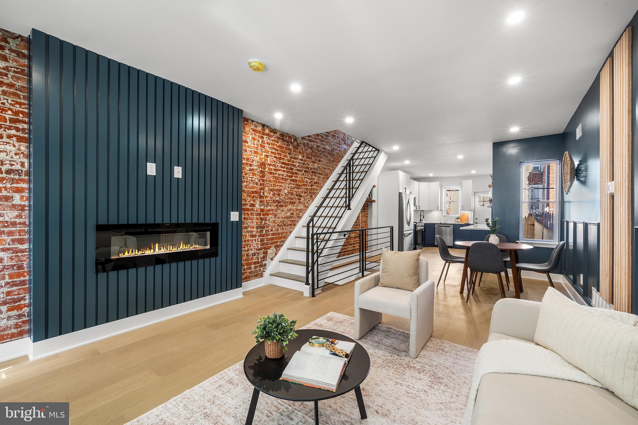 Welcome to this fully renovated gem in the heart of Port Richmond! Boasting 3 bedrooms, 2 full baths, a finished basement, and a fenced-in concrete backyard, this home offers the perfect blend of modern luxury and everyday comfort. Upon entering, find yourself in an enclosed, sun-drenched porch. Further inside, the living room is a showstopper, featuring bold dark blue walls, exposed brick, and an electric fireplace that adds warmth and character. The open floor plan flows seamlessly into the gourmet kitchen, complete with stainless steel appliances, floating wood shelves, and stunning veined quartz countertops. A door off the kitchen leads to your private backyard oasis—ideal for entertaining or quiet evenings outdoors. Upstairs, you'll find three bedrooms, including the primary, which wows with a fun, green accent wall. A full bath with a shower/tub is also on this floor. The fully finished basement adds even more functional living space, including a second full bath featuring a large walk-in shower and a laundry area for added convenience. Don't miss this opportunity—schedule a showing today!