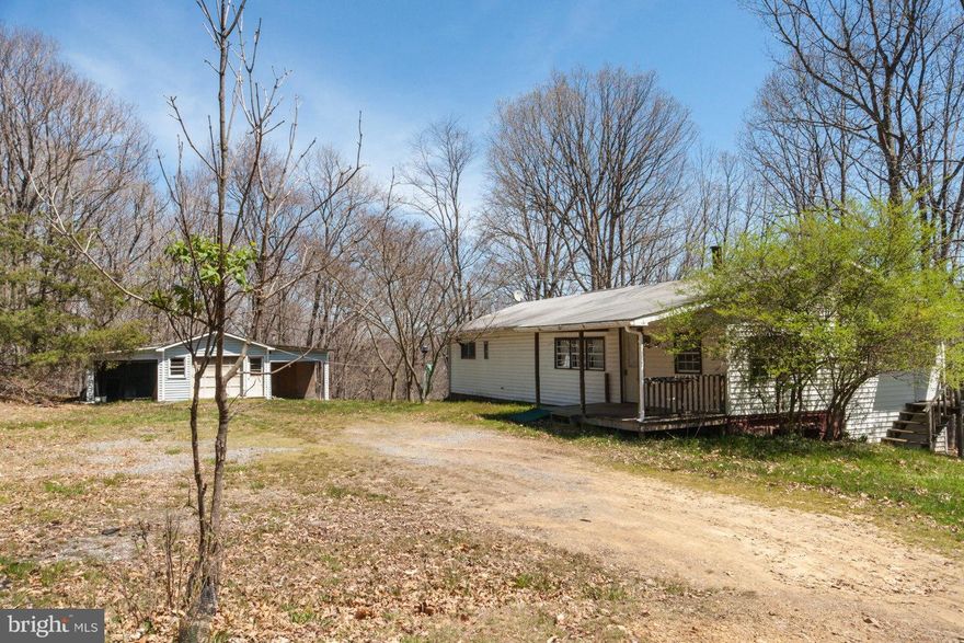 5.55 unrestricted acres with double wide available immediately.  Home features 2-3 bedrooms, spacious family room with wood stove hookup, covered front porch, two detached block buildings, detached garage with two side overhangs for equipment.  Sold as-is.