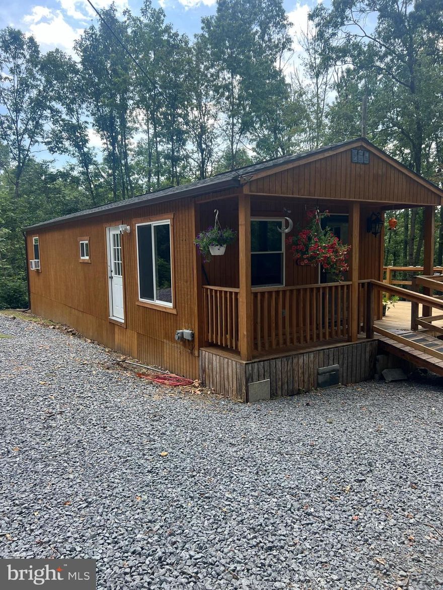 What a great find! Immaculate 1/1 home built in 2022 with well and septic, and hot water heater. All appliances are two years old with an upgraded washer and dryer. This property conveys with two lots in North River Bend, lots 16 & 17. Lot 16 has a driveway cut in and a power pole for guests, or you could build another dwelling for family. The main house is 672 sq ft and only two years old, in immaculate condition. There are 4 sheds on the property for storage and a generator hook-up. North River Bend also adjoins Short Mountain and 8,000 acres for additional recreational opportunities. Owners must find a property of choice prior to settlement.