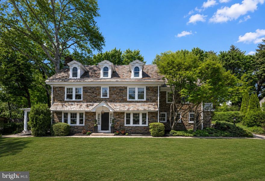OPEN HOUSES THURSDAY 5/14, 1-4, SAT & SUN, 1-3pm. Built in 1927 by architect Franklin Edmunds  for Walker E. Linvill and thoughtfully reimagined for today’s living, this stately stone Colonial seamlessly blends timeless character with a design-forward renovation. Set on a wide .4-acre lot, the home offers 5 bedrooms, 4 full baths, and 1 half bath across beautifully finished living spaces. A welcoming vestibule opens to a gracious, wide center hall. To the left, the expansive living room is anchored by a wood-burning fireplace and framed by French doors leading to a charming side porch—an ideal spot for morning coffee or quiet evenings. To the right, the formal dining room with classic chair rail detailing flows effortlessly into the beautiful, brand-new gourmet kitchen. Designed with both style and function in mind, the kitchen features a dramatic 9-foot island with quartz countertops, stainless steel appliances, double ovens, a Bosch dishwasher, Sub-Zero refrigerator, and a 5-burner gas cooktop—perfect for everyday living and entertaining alike. A mudroom with built-in bar and wine refrigerator, a convenient half bath with fun wallpaper and an attached two-car garage complete the main level. Upstairs, the second floor offers four bedrooms and three full baths, including a luxurious primary suite with a spacious bedroom, dual closets, and a beautifully renovated bath featuring an oversized shower with rain head, frameless glass enclosure, and double vanity. Additional bedrooms are generously sized—one with a bonus room—alongside a hall bath and a private bedroom suite with a charming clawfoot tub. A well-placed laundry room with barn door adds everyday convenience. The finished third floor expands the living space with a fifth bedroom, a full bath with tub/shower combination, and a versatile lounge or family room—plus a substantial carpeted storage area. Out back, a new slate patio sets the stage for effortless outdoor entertaining and al fresco dining. Central air conditioning installed in 2025. All this and a fabulous location, one mile to Suburban Square and close to the award winning Lower Merion High School. One of the listing agents has a financial interest in the property.
