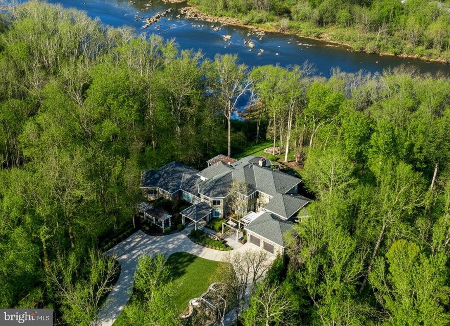 Commanding an incomparable vantage point above the Potomac River, this extraordinary stone estate by BOWA defines timeless sophistication and total privacy on more than three gated acres in McLean’s most coveted enclave, moments from Washington, D.C.

Beyond its stately approach and manicured grounds, the residence reveals  16,000 square feet of refined interiors designed for both grand entertaining and serene daily living. A two-story great room with floor-to-ceiling windows frames sweeping river views, while French doors open to an expansive terrace that captures the tranquil beauty of the surroundings.

The gourmet kitchen is a showpiece with professional-grade appliances, granite surfaces, a walk-in pantry with Sub-Zero refrigerator, and a hidden bar. The main level also offers dual offices, two powder rooms, elevator access, and a full laundry with pet bath—all under soaring ceilings that enhance light and volume.

The main-level owner’s suite is a private sanctuary with windows on three sides, dual dressing rooms, and a marble spa bath with jetted tub, steam shower, and private balcony overlooking the river. Upstairs, three guest suites each feature walk-in closets and elegant baths, two with French doors to balconies.

The lower level is a destination in itself—featuring a lounge with stone fireplace, billiards area, wet bar, wine cellar, fitness room, and a stunning indoor pool with skylights and glass doors opening to extensive stone patios. Additional amenities include a private in-law or staff suite with full kitchen, a salon, guest suite, and generous storage.

Outside, terraced gardens, pergolas, water features, and a gazebo with full outdoor kitchen create a breathtaking resort-style setting. With five-car garage parking, geothermal systems, and whole-house generator, this distinguished estate offers rare scale, craftsmanship, and uninterrupted Potomac River views.