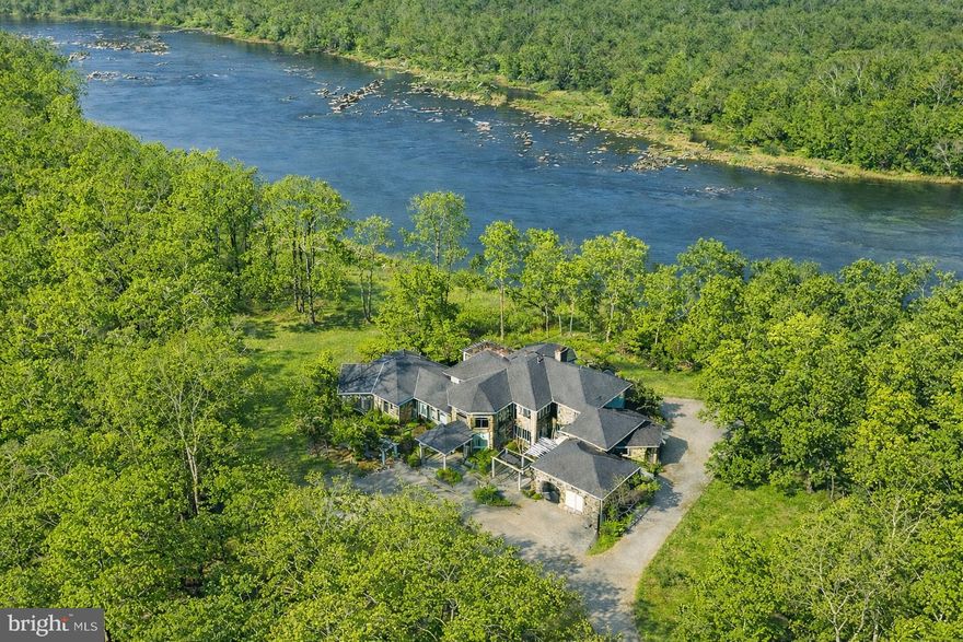 Commanding an incomparable vantage point above the Potomac River, this extraordinary stone estate by BOWA defines timeless sophistication and total privacy on more than three gated acres in McLean’s most coveted enclave, moments from Washington, D.C.

Beyond its stately approach and manicured grounds, the residence reveals over 16,000 square feet of refined interiors designed for both grand entertaining and serene daily living. A two-story great room with floor-to-ceiling windows frames sweeping river views, while French doors open to an expansive terrace that captures the tranquil beauty of the surroundings.

The gourmet kitchen is a showpiece with professional-grade appliances, granite surfaces, a walk-in pantry with Sub-Zero refrigerator, and a hidden bar. The main level also offers dual offices, two powder rooms, elevator access, and a full laundry with pet bath—all under soaring ceilings that enhance light and volume.

The main-level owner’s suite is a private sanctuary with windows on three sides, dual dressing rooms, and a marble spa bath with jetted tub, steam shower, and private balcony overlooking the river. Upstairs, three guest suites each feature walk-in closets and elegant baths, two with French doors to balconies.

The lower level is a destination in itself—featuring a lounge with stone fireplace, billiards area, wet bar, wine cellar, fitness room, and a stunning indoor pool with skylights and glass doors opening to extensive stone patios. Additional amenities include a private in-law or staff suite with full kitchen, a salon, guest suite, and generous storage.

Outside, terraced gardens, pergolas, water features, and a gazebo with full outdoor kitchen create a breathtaking resort-style setting. With five-car garage parking, geothermal systems, and whole-house generator, this distinguished estate offers rare scale, craftsmanship, and uninterrupted Potomac River views.